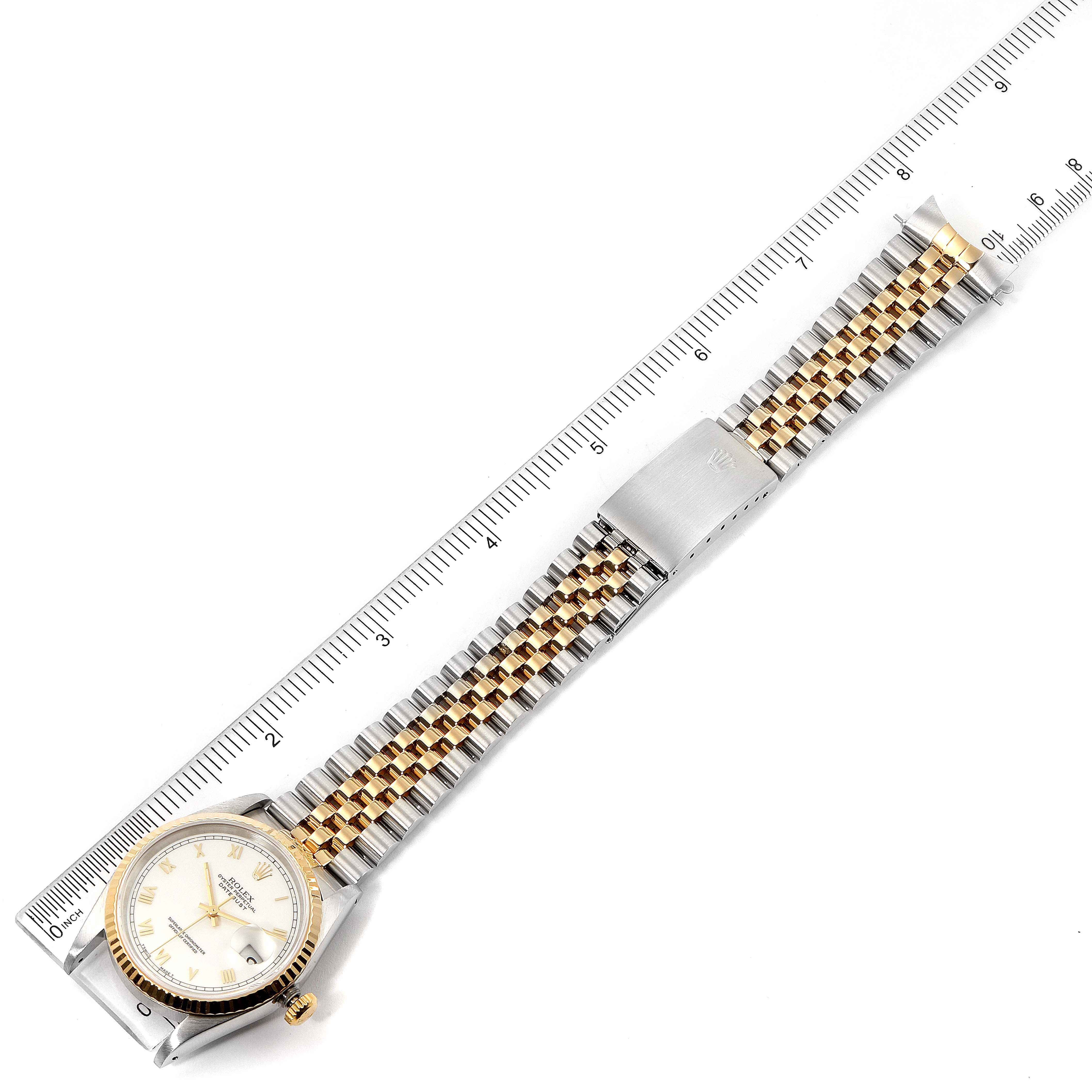 The image shows a full view of the Rolex Datejust 16233 Men's Steel and Gold (two tone) White Dial 16233 Men's Steel and Gold (two tone) White Dial watch laid flat against a ruler, displaying the dial, bracelet, and clasp.