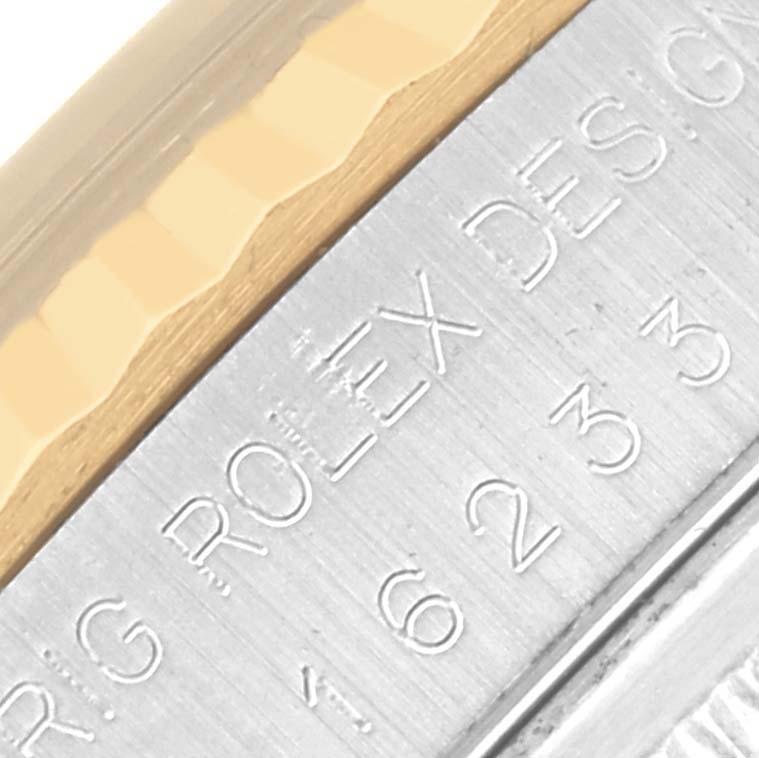 The image shows a close-up of the edge of a Rolex Datejust 16233 Men's Steel and Gold (two tone) Blue Dial 16233 Men's Steel and Gold (two tone) Blue Dial watch, focusing on the gold and silver metallic details.