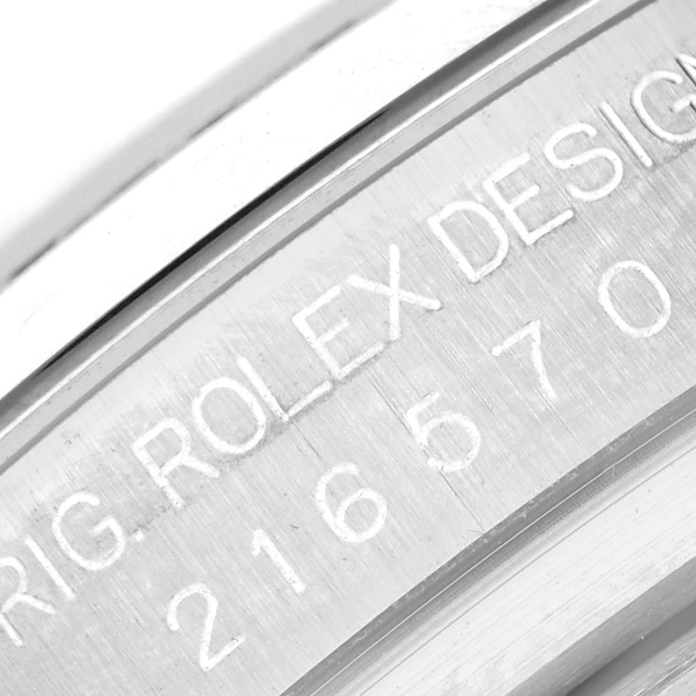 The image shows a close-up of the engraved serial number and "ROLEX DESIGN" text on the case of a Rolex Explorer 216570 Men's Stainless Steel Black Dial 216570 Men's Stainless Steel Black Dial watch.