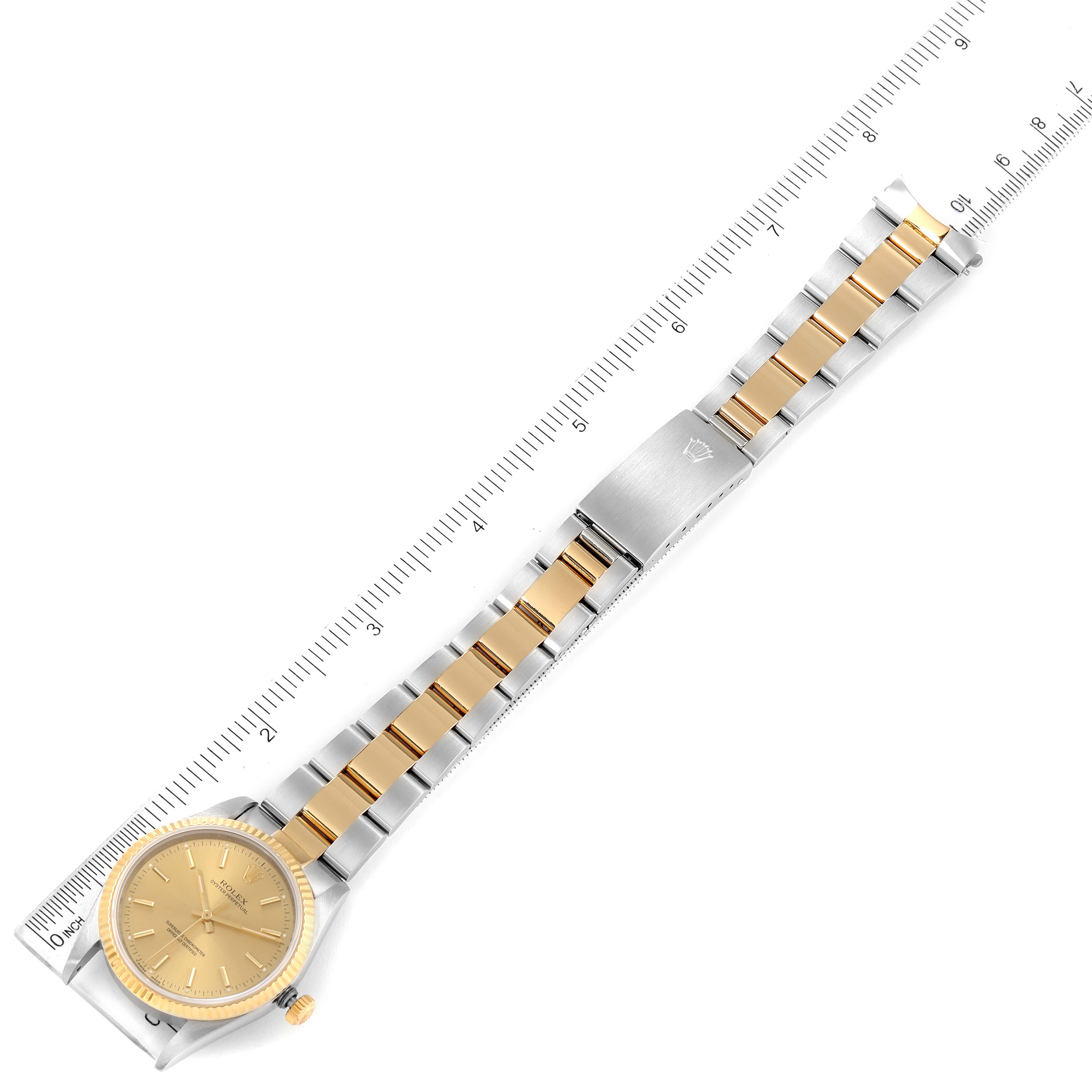 The Rolex Oyster Perpetual 14233 Men
s Steel and Gold (two tone) Champagne Dial 14233 Men
s Steel and Gold (two tone) Champagne Dial watch is shown flat with a ruler, displaying the face, bracelet, and clasp in a top-down view.