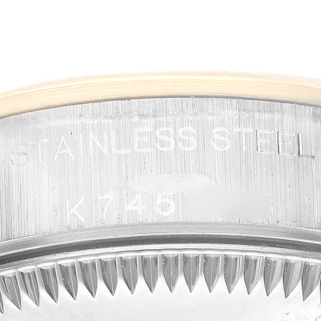 This image shows a close-up of the case back and partial rehaut of a Rolex Oyster Perpetual K745869 Women's Steel and Gold (two tone) Silver Dial K745869 Women's Steel and Gold (two tone) Silver Dial watch.