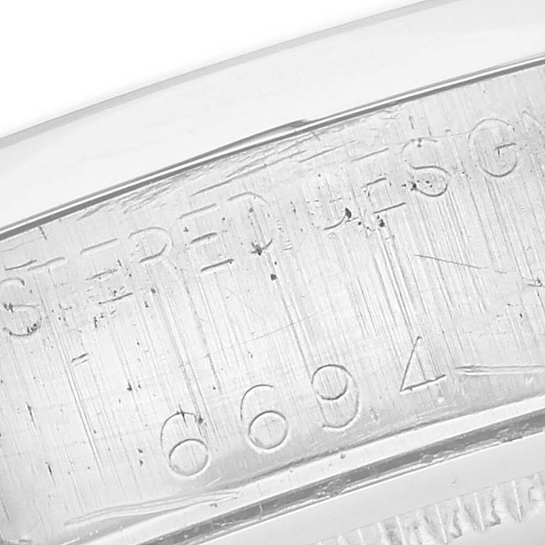 The image shows a close-up of the engraved inner bezel of a Rolex Date 6694 Men's Stainless Steel Black Dial 6694 Men's Stainless Steel Black Dial watch.