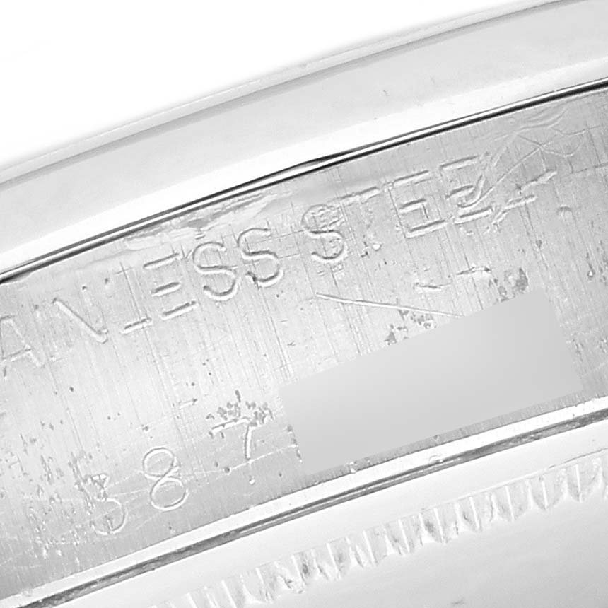 The image shows a close-up of the engraved serial number area on a Rolex Date 6694 Men's Stainless Steel Black Dial 6694 Men's Stainless Steel Black Dial watch, highlighting the "STAINLESS STEEL" engraving.