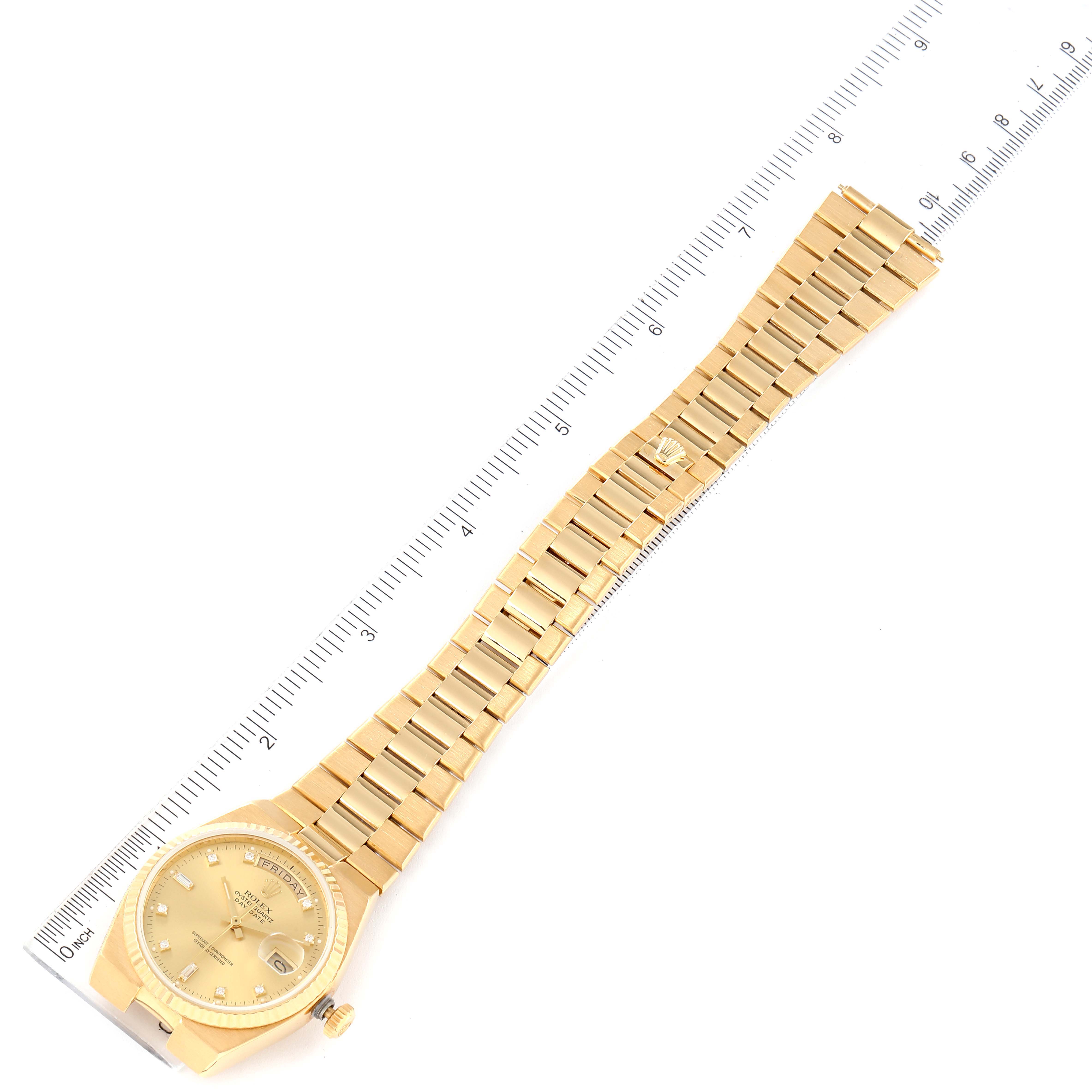 The Rolex Oysterquartz 19018 Men's Yellow Gold Champagne Dial 19018 Men's Yellow Gold Champagne Dial watch is displayed in a flat, top-down angle, showing the face and full bracelet laid alongside a ruler for scale.