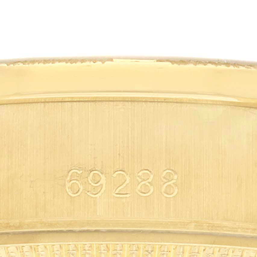 The image shows a close-up of the Rolex President 69288 Women's Yellow Gold Champagne Dial 69288 Women's Yellow Gold Champagne Dial model, focusing on the engraved edge likely representing the case or bezel.