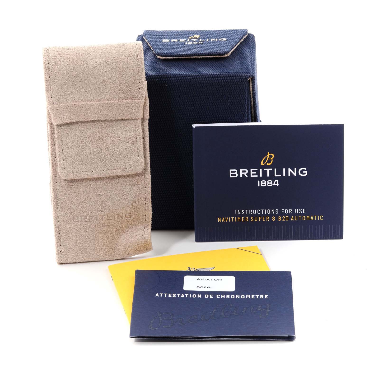 The image shows a set of accessories for a Breitling Navitimer watch, including a box, a suede pouch, and instruction booklets.