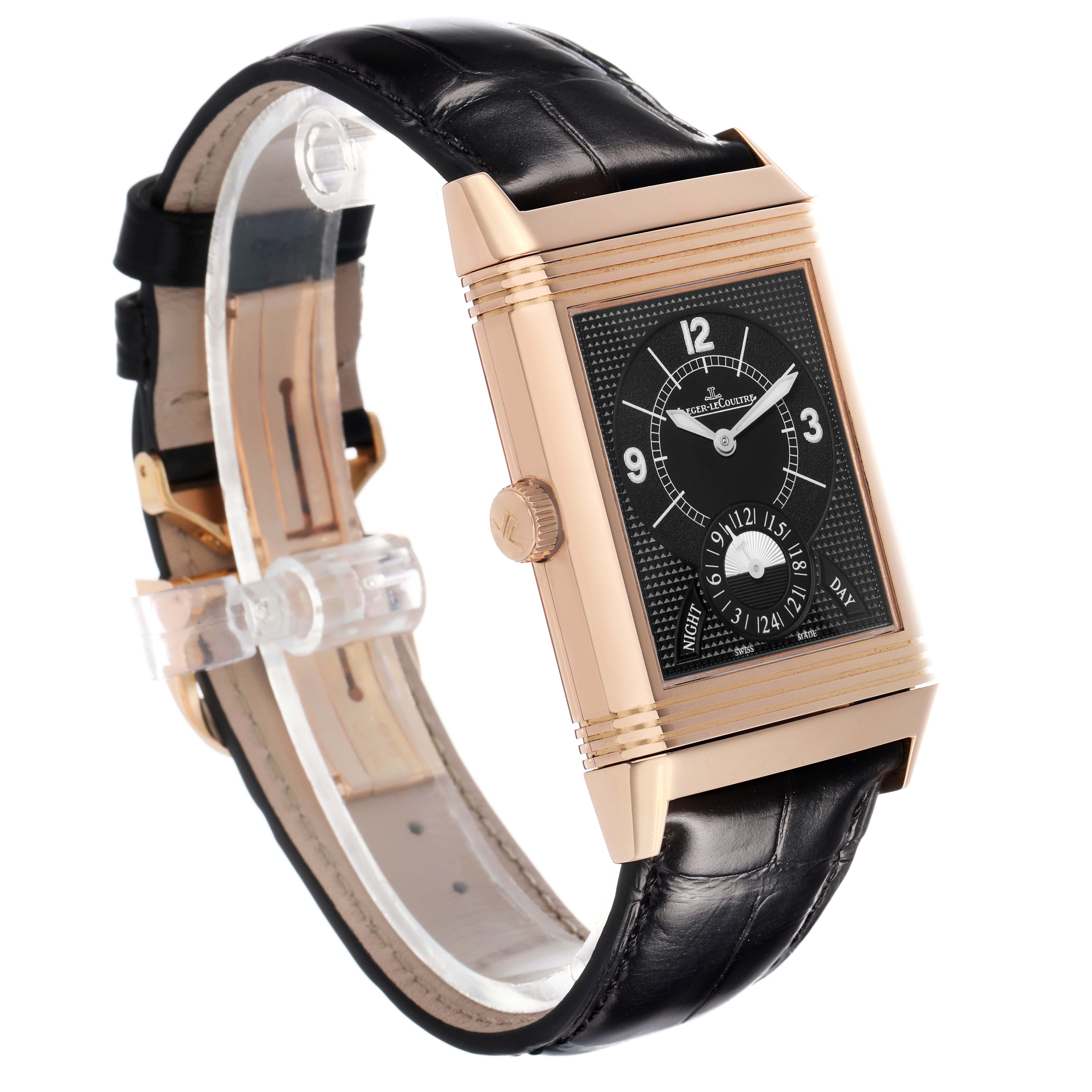 The Jaeger-LeCoultre Reverso watch is shown at a three-quarter angle, highlighting its rectangular face, rose gold case, black dial, and leather strap.