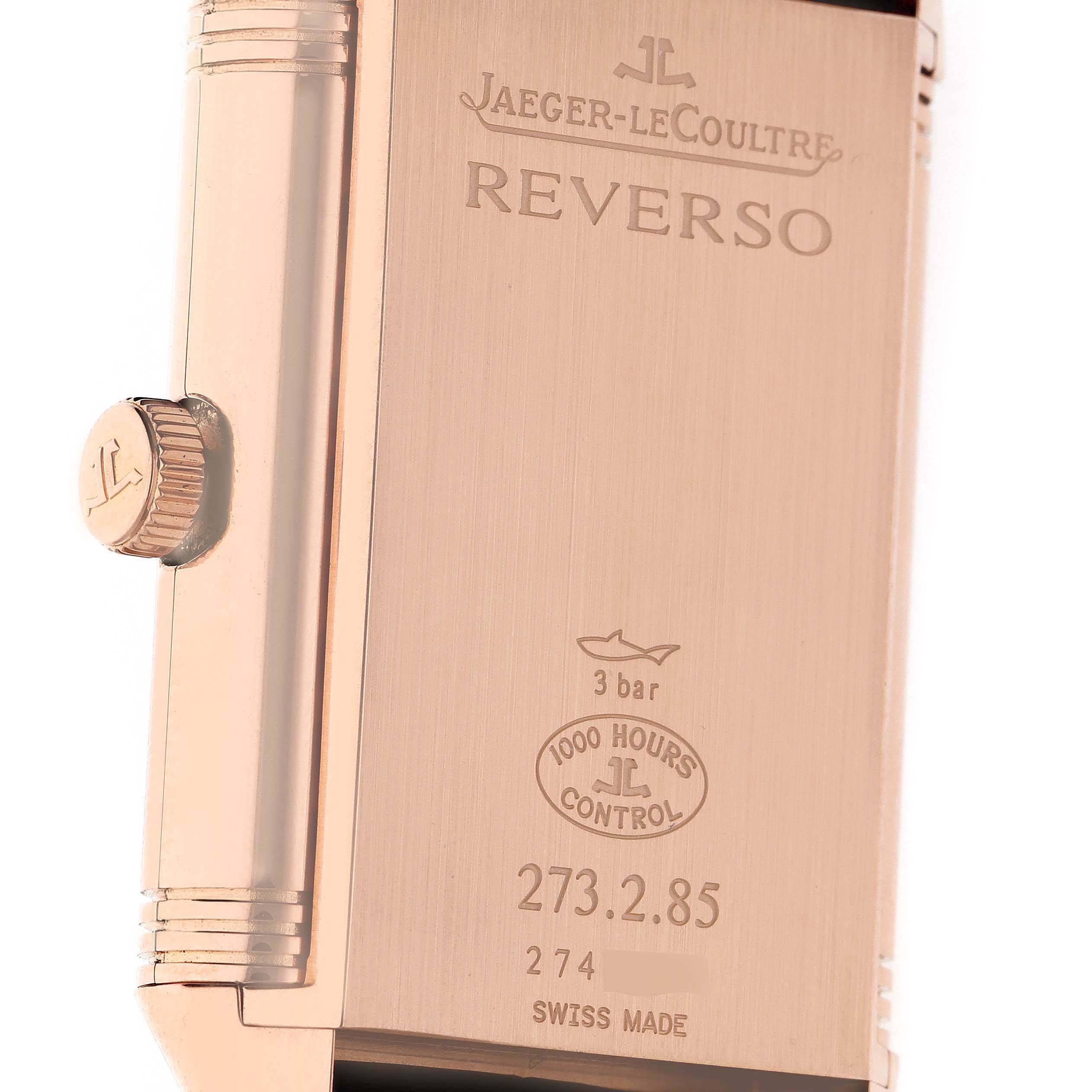 The image shows the back of a Jaeger-LeCoultre Reverso watch, featuring the brand logo, model name, and specifications.