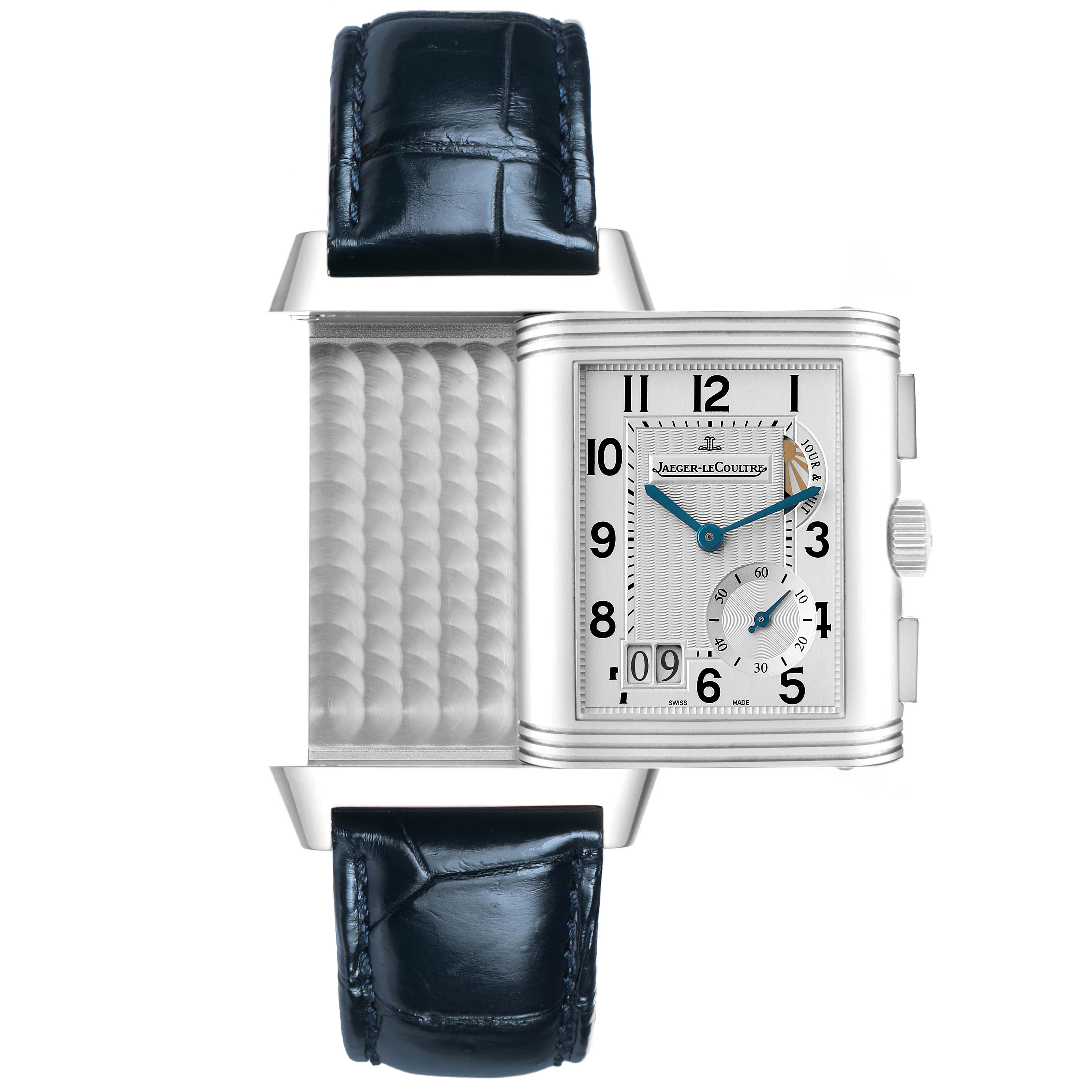 The Jaeger-LeCoultre Reverso watch is shown at an angle revealing its swiveling mechanism and detailed dial with a visible strap.