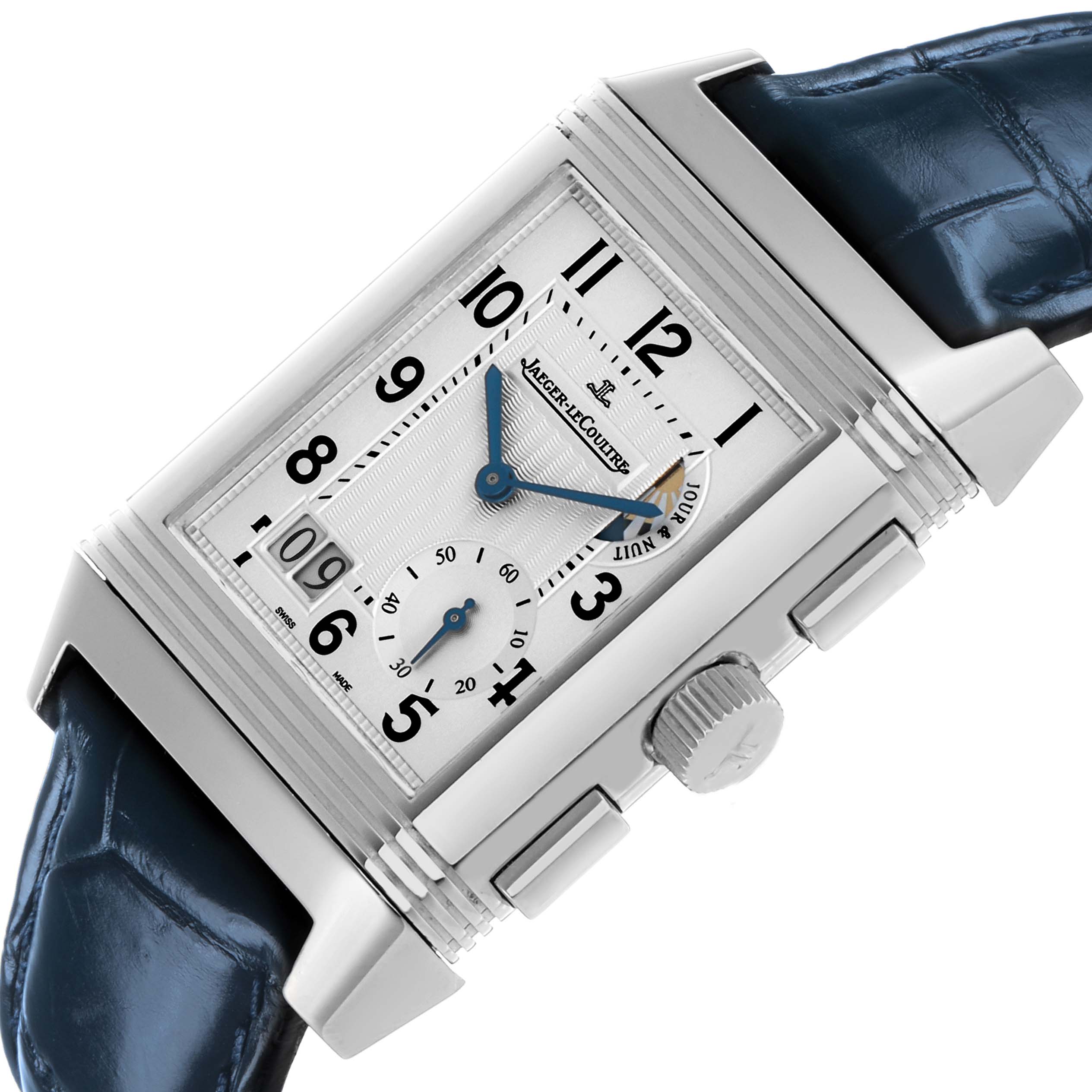 The Jaeger-LeCoultre Reverso watch is shown at an angled view, displaying the dial, crown, and partial blue leather strap.