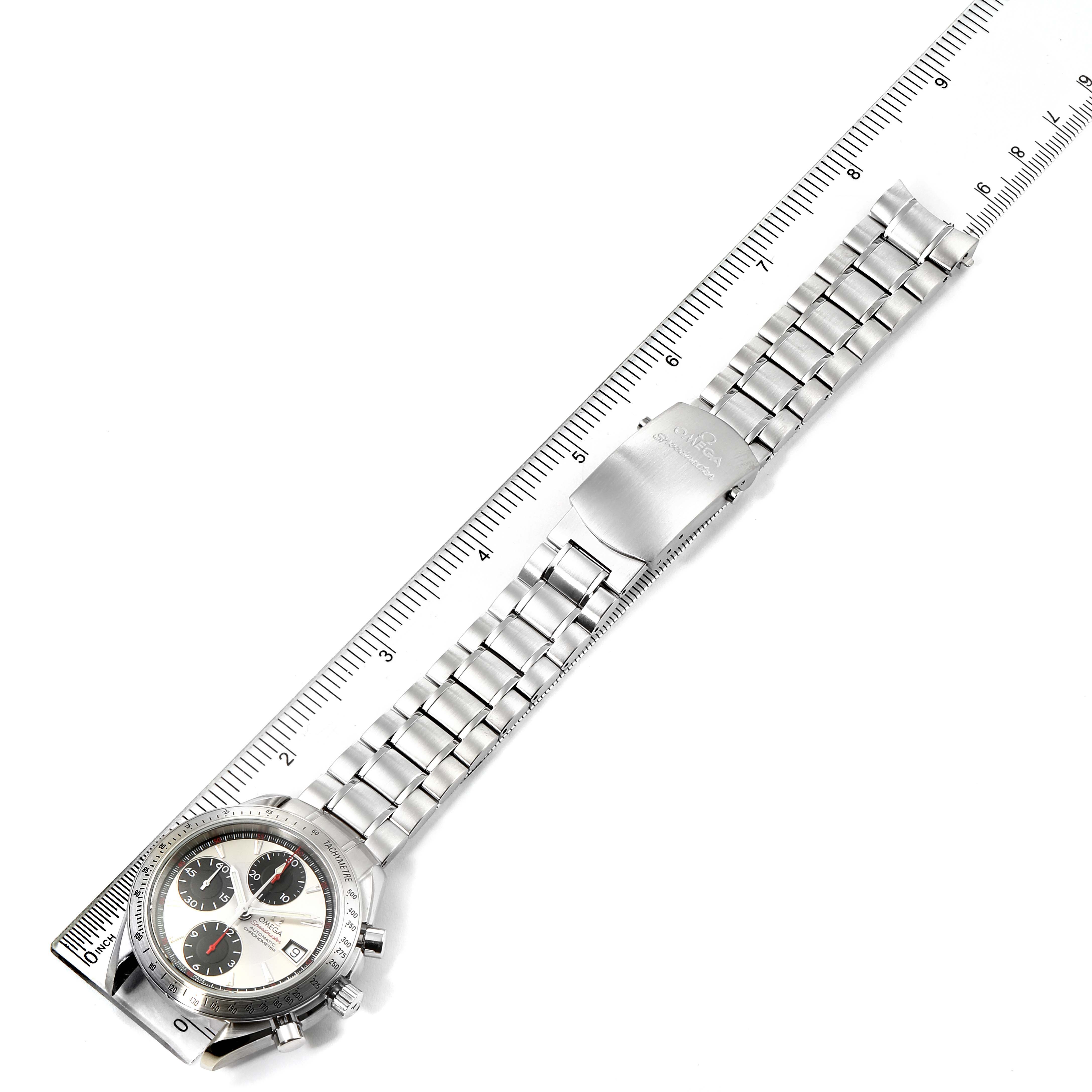 The image shows an Omega Speedmaster 3211.31.00 Men
s Stainless Steel Silver Dial 3211.31.00 Men
s Stainless Steel Silver Dial watch from an overhead angle, including its face, bracelet, and clasp, with a ruler for scale.
