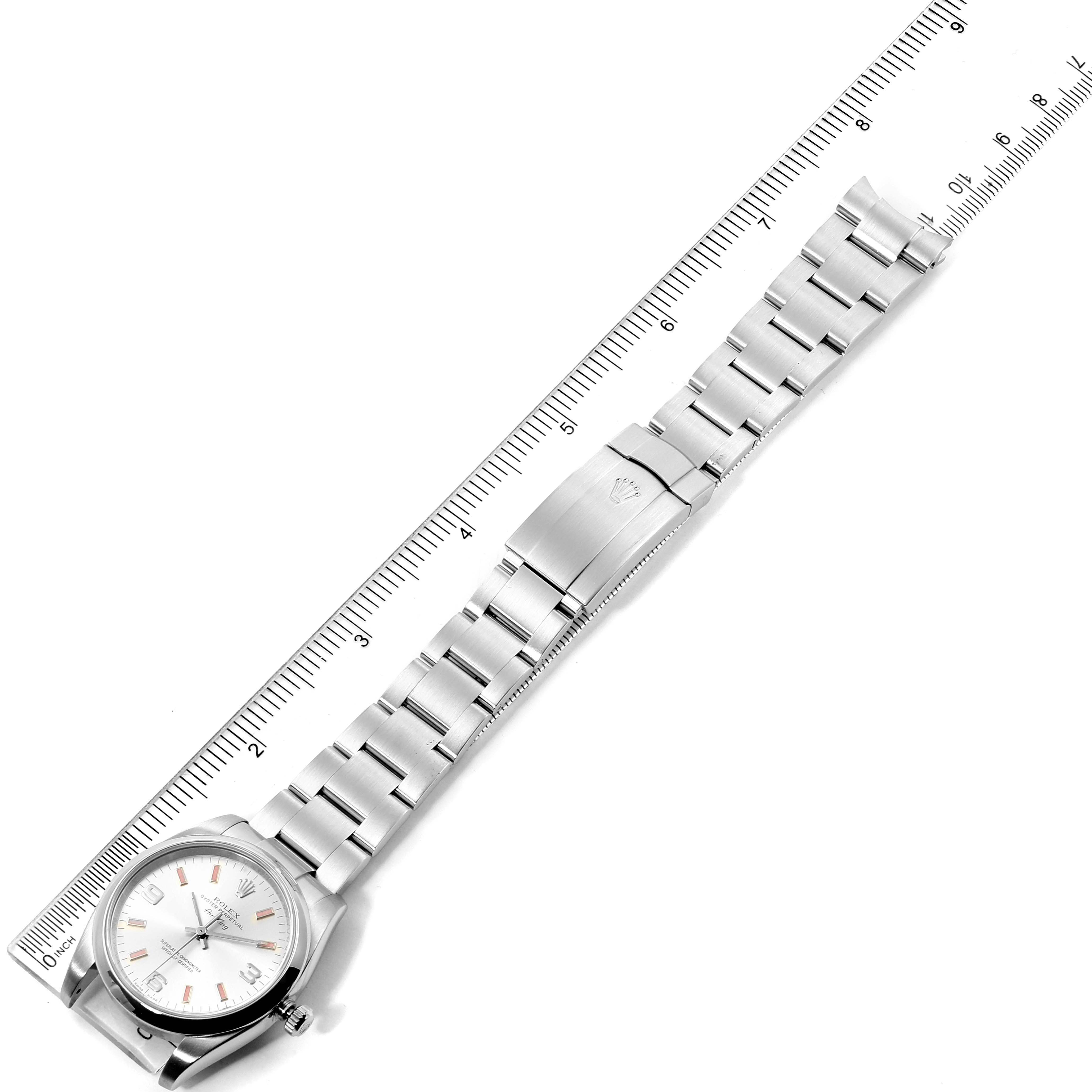 The image shows an overhead view of a Rolex Air-King 114200 Men's Stainless Steel Silver Dial 114200 Men's Stainless Steel Silver Dial watch, featuring the face, bracelet, and a ruler for scale.