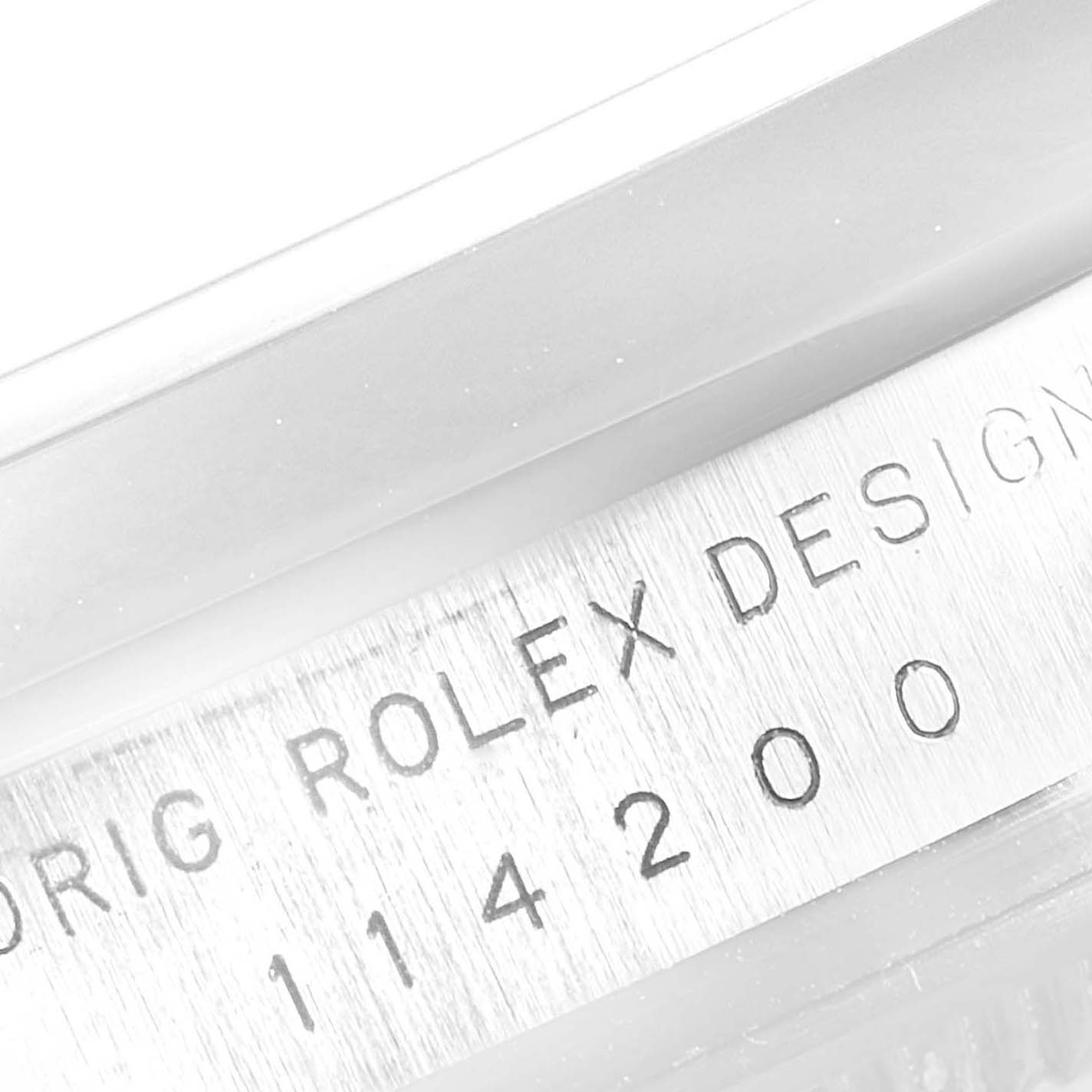 This close-up image shows the etched serial number and "ROLEX DESIGN" inscription on the side of the Rolex Air-King 114200 Men's Stainless Steel Silver Dial 114200 Men's Stainless Steel Silver Dial watch case.