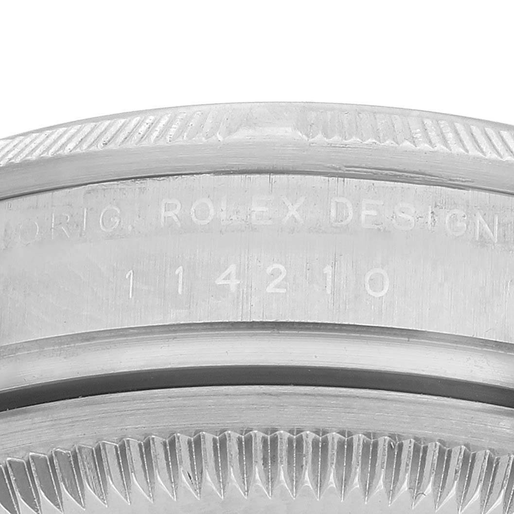 The image shows a close-up of the rim and engraving on a Rolex Air-King 114210 Men's Stainless Steel Silver Dial watch, focusing on the serial number area.