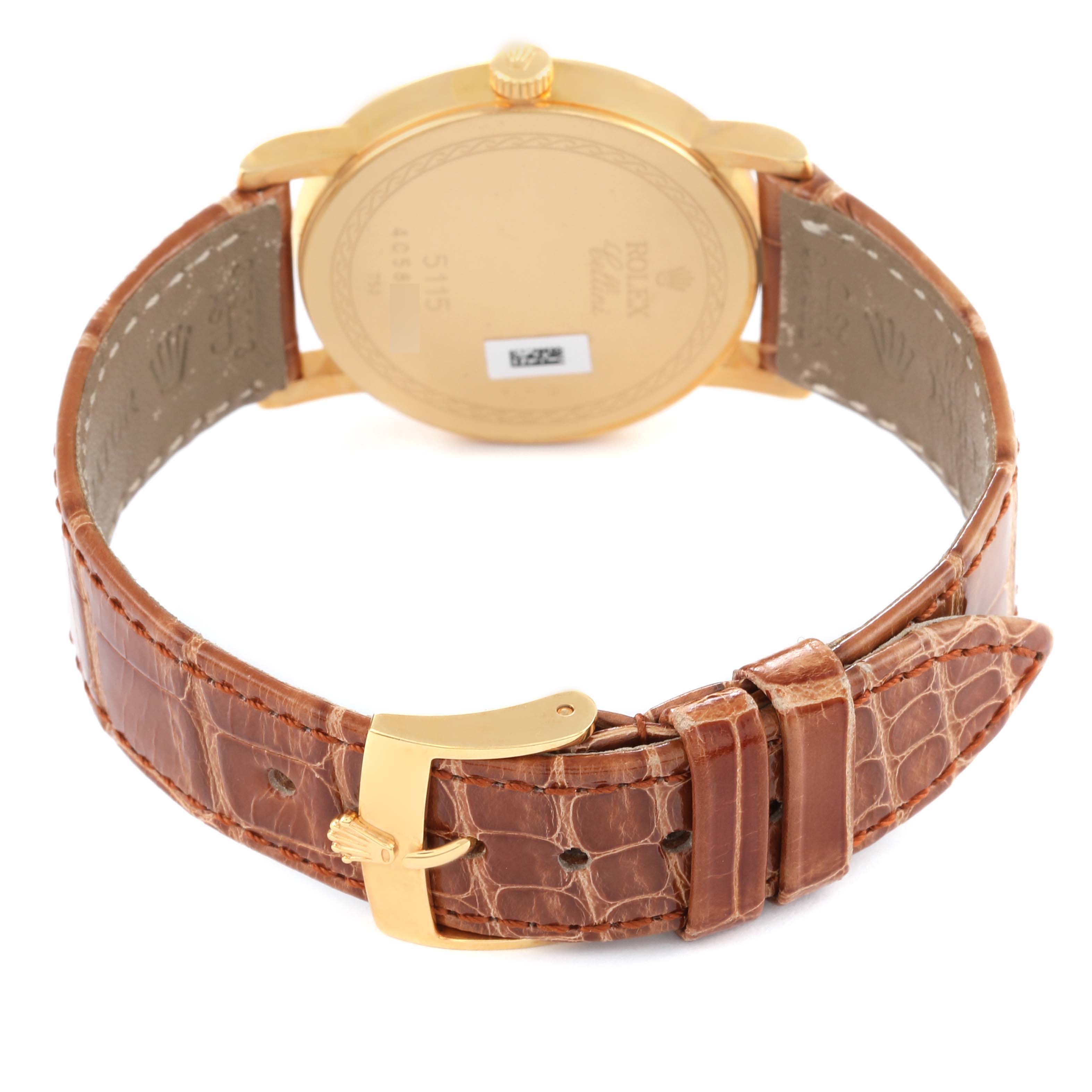 The image shows the back of a Rolex Cellini 5115/8 Men's Yellow Gold Mother of Pearl Dial 5115/8 Men's Yellow Gold Mother of Pearl Dial watch, highlighting its gold casing and brown leather strap with a gold clasp.
