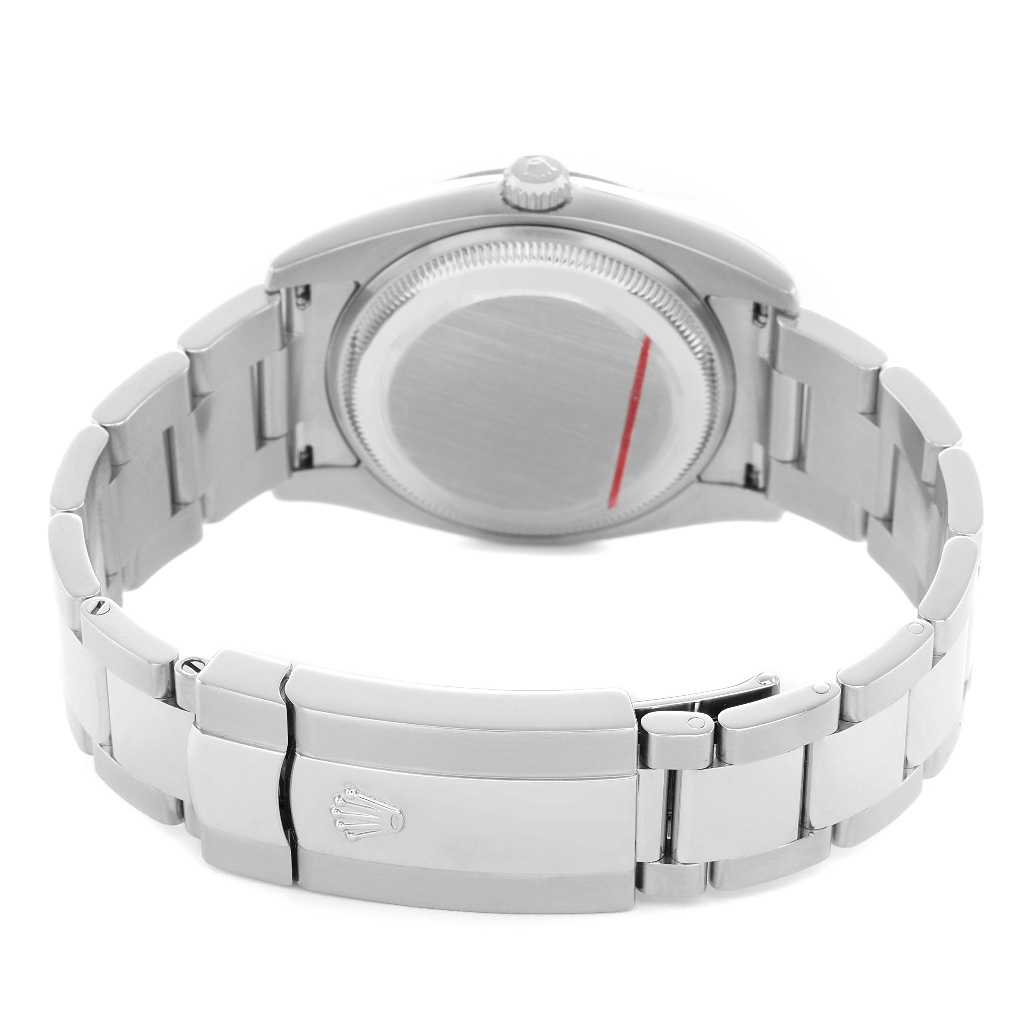 The image shows the back of a Rolex Date 115210 Men's Stainless Steel Black Dial model watch, highlighting the case back and the bracelet with the clasp.