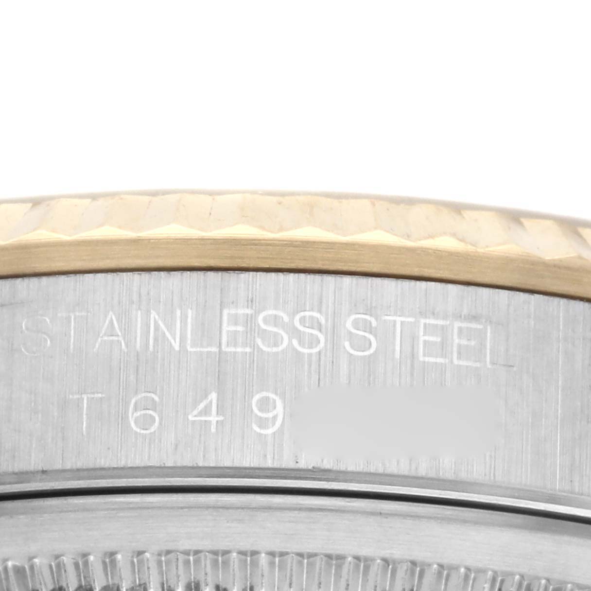The image shows a close-up angle of the Rolex Datejust 16233 Men's Steel and Gold (two tone) Champagne Dial 16233 Men's Steel and Gold (two tone) Champagne Dial model, focusing on the fluted bezel and engraved case markings.