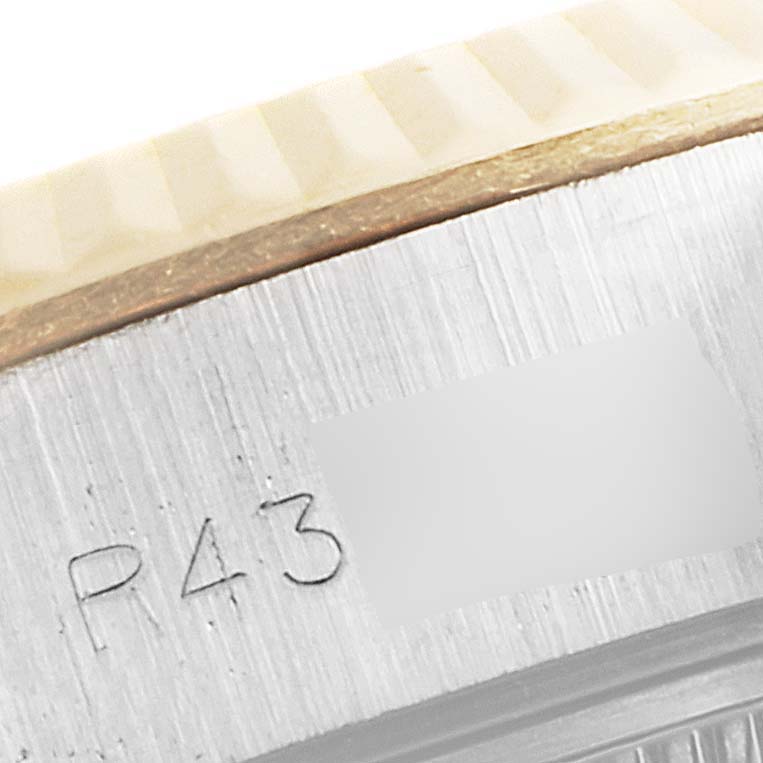 The image shows an angled close-up of the Rolex Datejust 69173 Women's Steel and Gold (two tone) Champagne Dial 69173 Women's Steel and Gold (two tone) Champagne Dial watch's edge, highlighting the serial number and part of the fluted bezel.