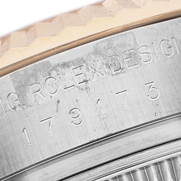 The image shows a close-up of the side of the Rolex Datejust 179173 Women's Steel and Gold (two tone) Champagne Dial, focusing on the engraved serial and design numbers.