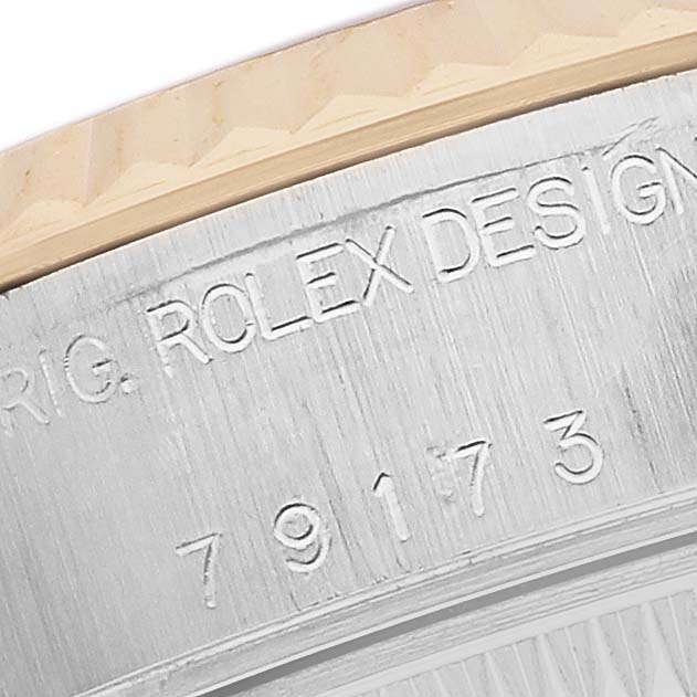 The image shows a close-up of the case side with engravings on a Rolex Datejust 79173 Women's Steel and Gold (two tone) Mother of Pearl Dial.