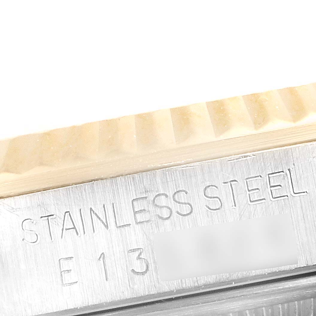 This image shows a close-up of the side view of a Rolex Datejust 16233 Men
s Steel and Gold (two tone) Grey Dial 16233 Men
s Steel and Gold (two tone) Grey Dial watch, highlighting its fluted bezel and "Stainless Steel" engraving.