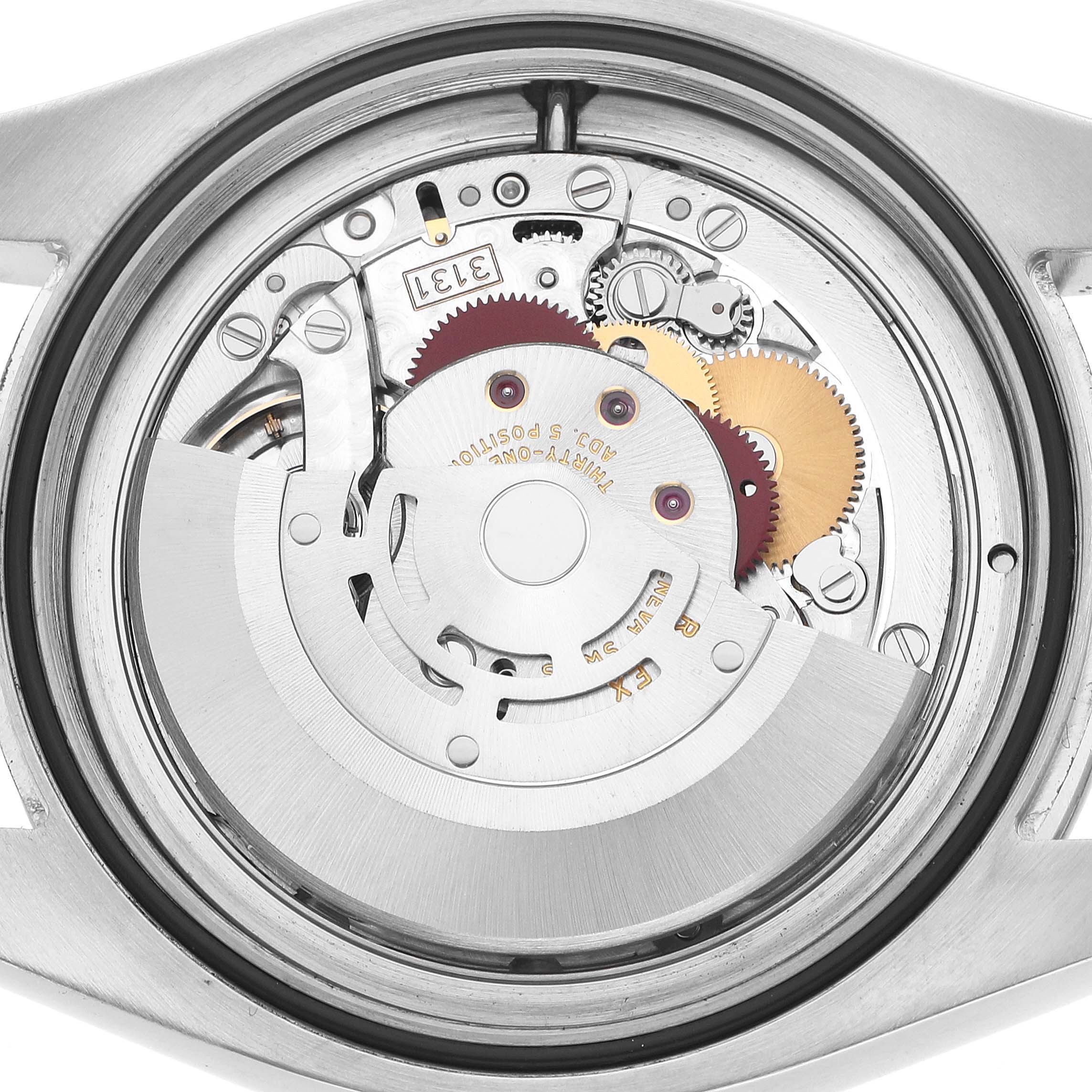 The image shows the inner mechanism of a Rolex Milgauss 116400 Men's Stainless Steel Black Dial watch, viewed from the back, showcasing gears and components.