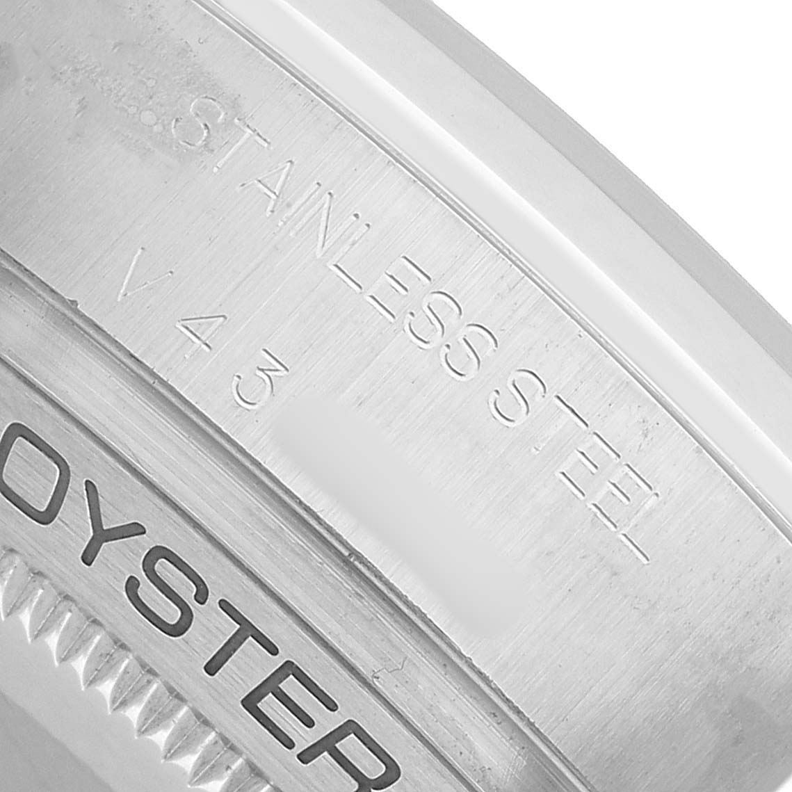 The image shows a close-up of the bezel's edge and inner engraving on a Rolex Milgauss 116400 Men's Stainless Steel Black Dial watch, highlighting the stainless steel and "OYSTER."