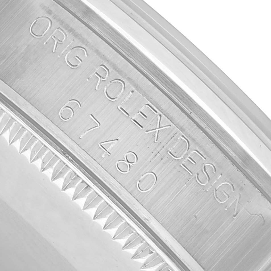 The image shows a close-up of the side of a Rolex Oyster Perpetual 67480 Women's Stainless Steel Pink Dial watch case, highlighting the engraved model number and design details.