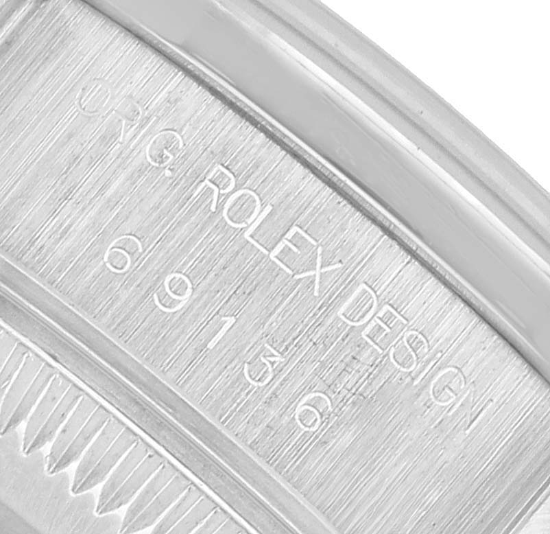 The image shows a close-up of a Rolex President 69136 Women's Platinum Silver Dial model, featuring its engraved bezel with model information.