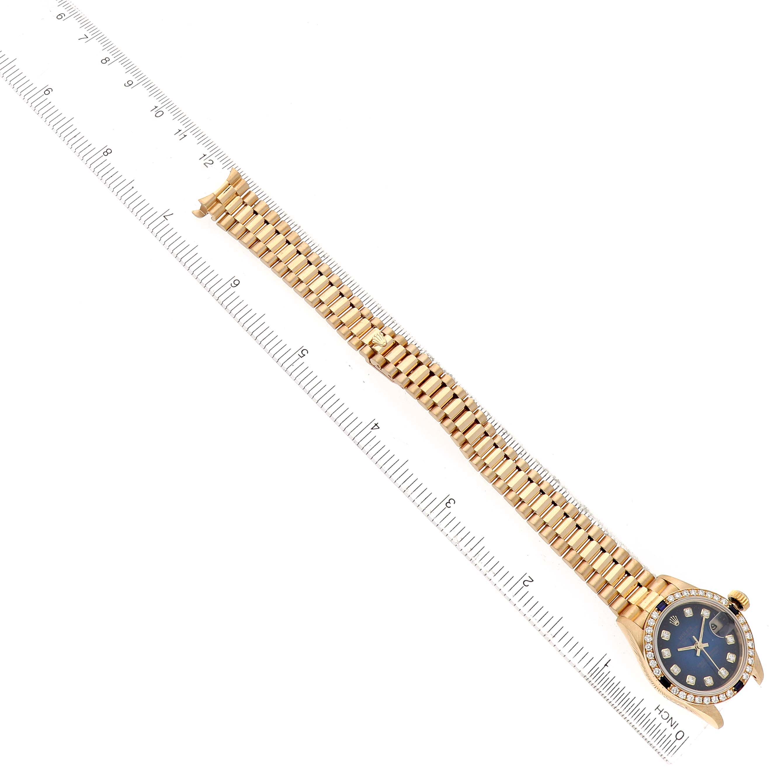 The image shows a Rolex President 69088 Women's Yellow Gold Blue Dial watch laid flat with a ruler, displaying the full bracelet and face from a top-down angle.