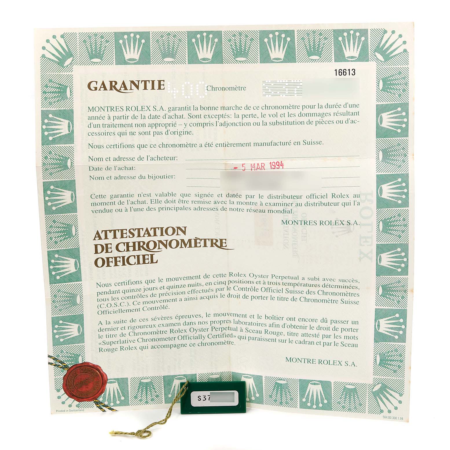 The image shows warranty and chronometer certificates for a Rolex Submariner 16613 Men
s Steel and Gold (two tone) Blue Dial 16613 Men
s Steel and Gold (two tone) Blue Dial model, along with a green tag.
