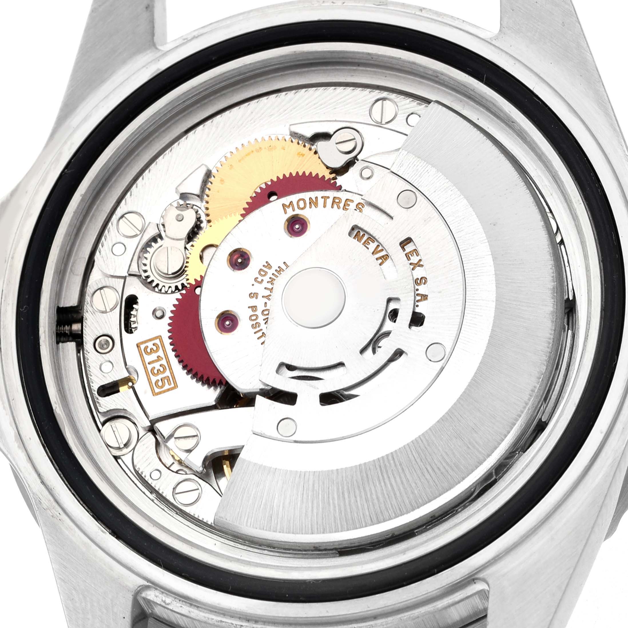 The image shows the movement of a Rolex Submariner 16610 Men's Stainless Steel Black Dial watch from a rear angle, showcasing its intricate mechanical parts.