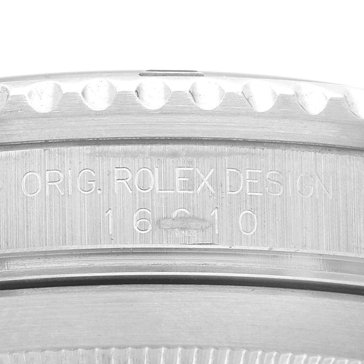 The image shows a close-up of the Rolex Submariner 16610 Men's Stainless Steel Black Dial's side, focusing on the engraved serial and design details.