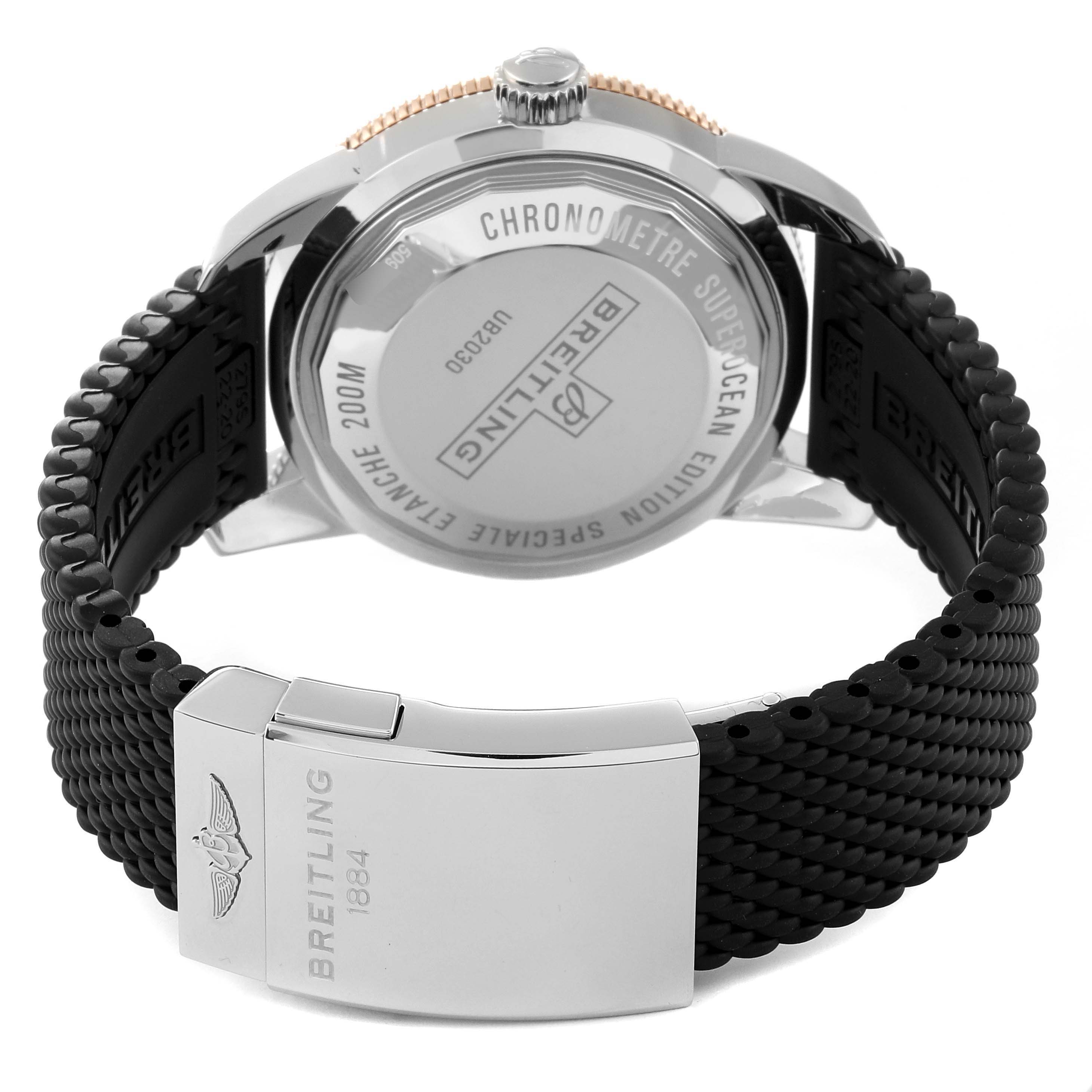 The image shows the back case and clasp of a Breitling Superocean UB2030121B1S1 Men's Steel and Gold (two tone) Black Dial UB2030121B1S1 Men's Steel and Gold (two tone) Black Dial watch, highlighting the engraved details and black strap.