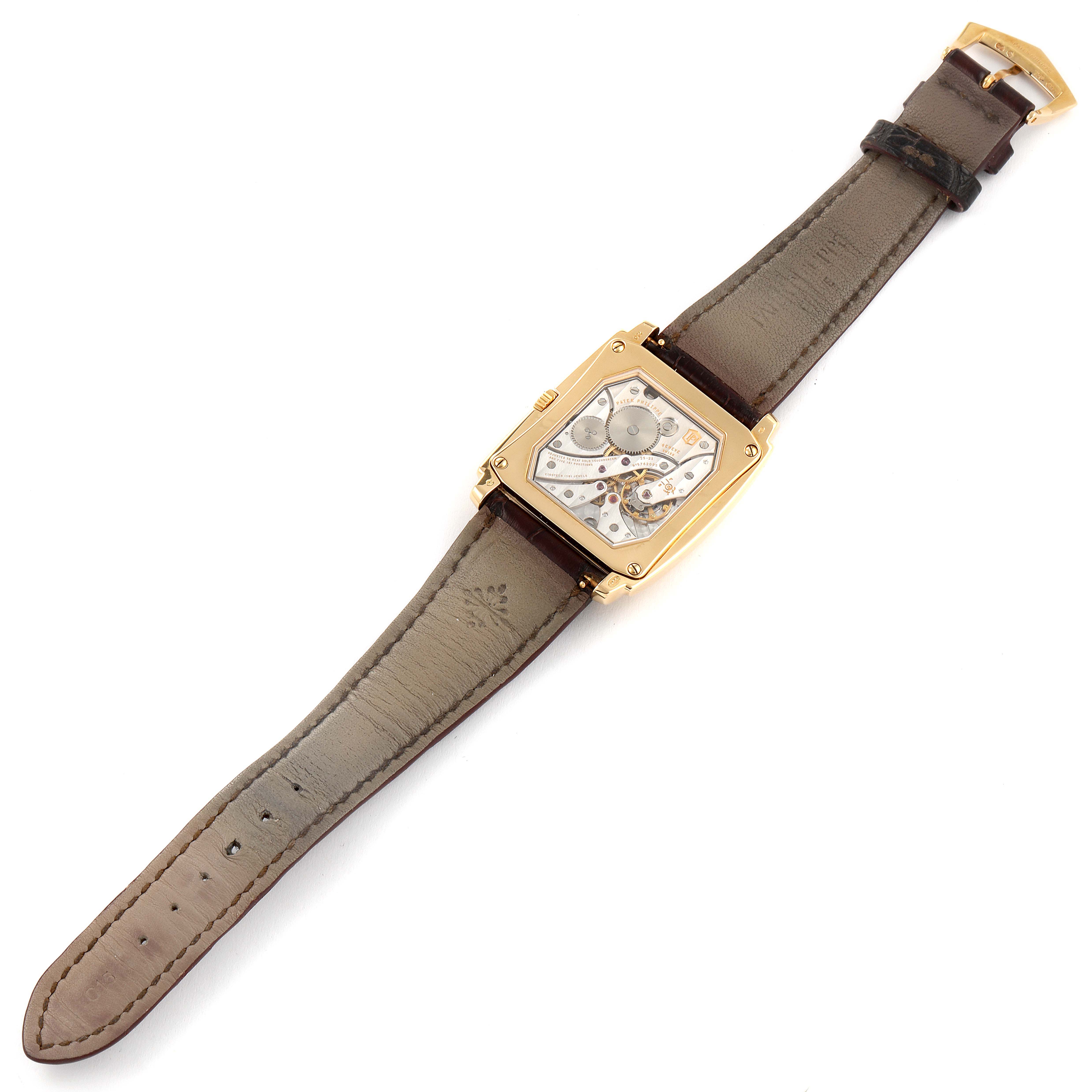 The image shows a top view of a Patek Philippe Gondolo 5124J Men's Yellow Gold Silver Dial 5124J Men's Yellow Gold Silver Dial model watch, displaying its back case, leather strap, and buckle.