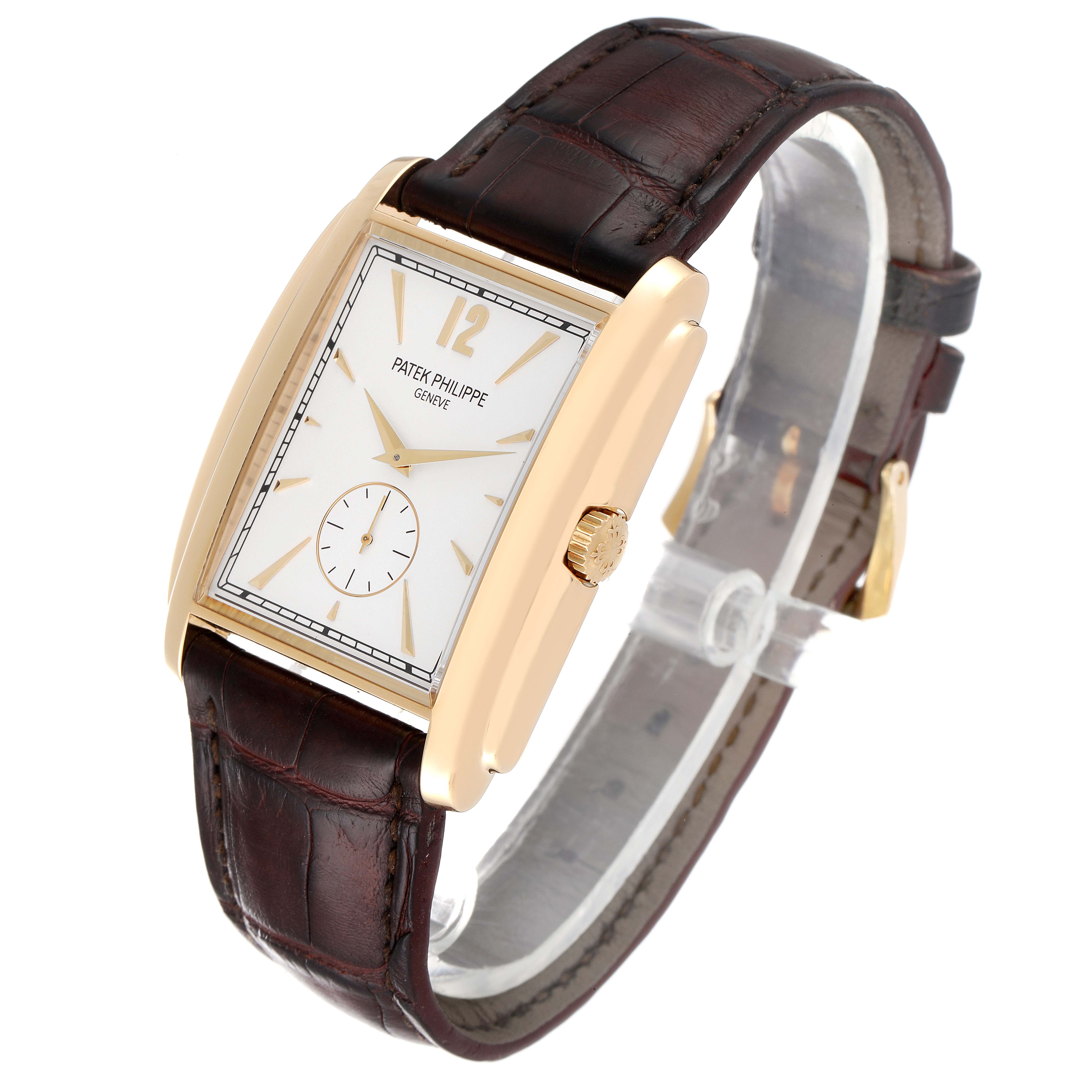The Patek Philippe Gondolo 5124J Men's Yellow Gold Silver Dial 5124J Men's Yellow Gold Silver Dial watch is shown at a slight angle, highlighting its rectangular dial, gold case, and brown leather strap.