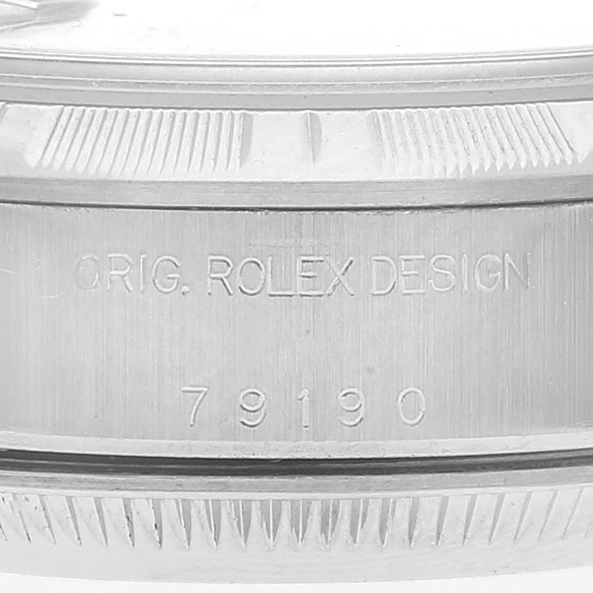 This image shows a close-up of the side of the Rolex Date 79190 Women
s Stainless Steel Black Dial 79190 Women
s Stainless Steel Black Dial model watch, highlighting its serial number and "Orig. Rolex Design" engraving.