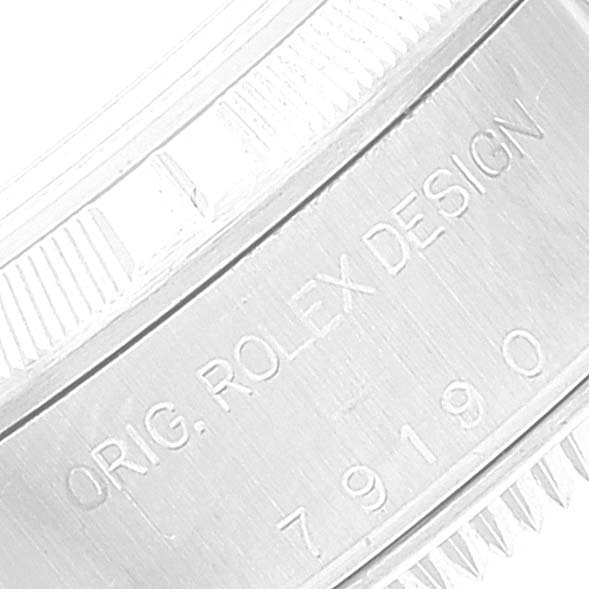 The image shows a close-up of the case side of a Rolex Date 79190 Women's Stainless Steel Silver Dial 79190 Women's Stainless Steel Silver Dial model watch with "ORIG. ROLEX DESIGN" and "79190" engravings.