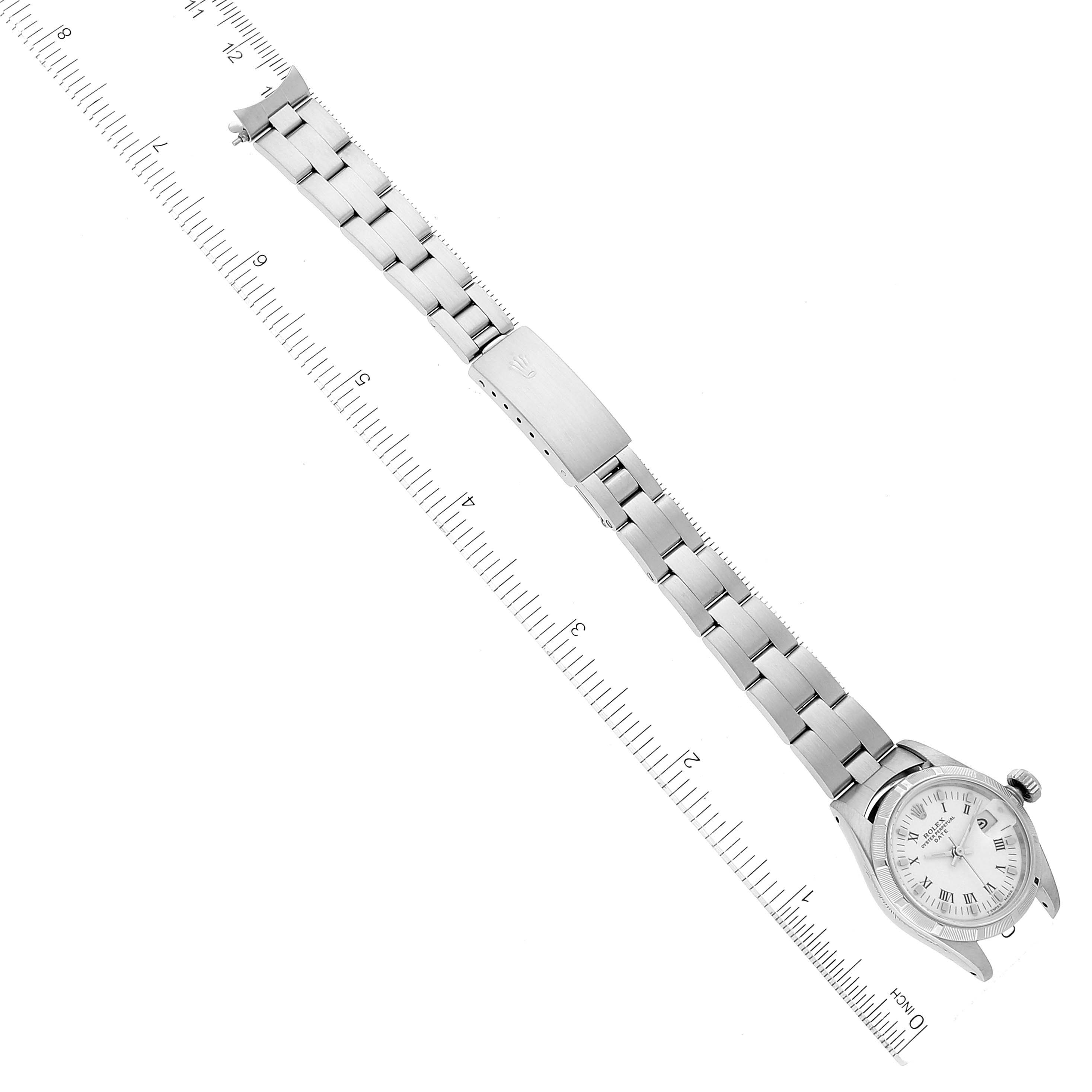 The Rolex Date 69190 Women's Stainless Steel White Dial 69190 Women's Stainless Steel White Dial watch is shown from a top-down angle, displaying its face, bracelet, and clasp against a measuring ruler.