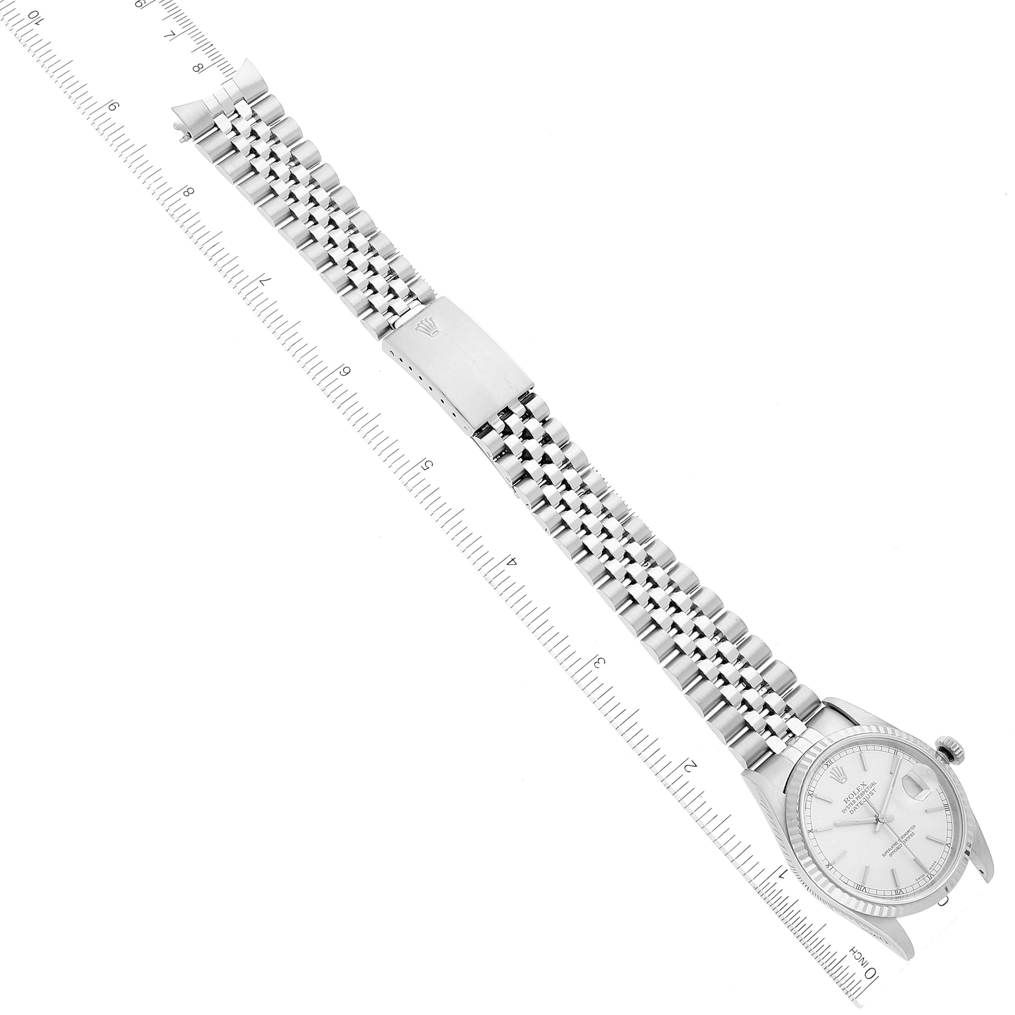 The image shows a top view of a Rolex Datejust 16234 Men's Stainless Steel Silver Dial 16234 Men's Stainless Steel Silver Dial watch with its full bracelet and clasp, alongside a ruler for scale.