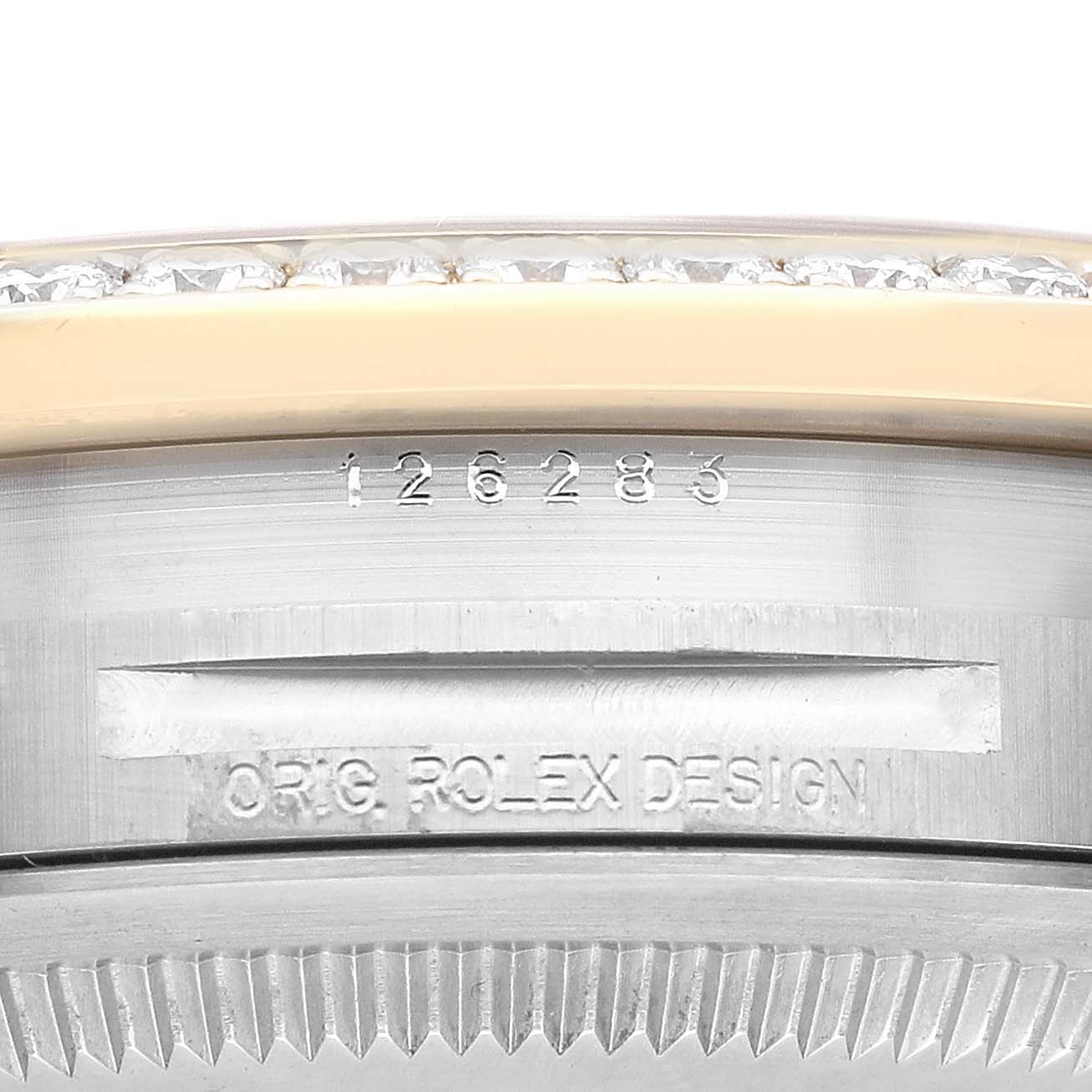 The image shows a close-up of the outer edge of a Rolex Datejust 126283RBR Men's Steel and Gold (two tone) Black Dial 126283RBR Men's Steel and Gold (two tone) Black Dial watch case, featuring engraved serial numbers and part of the bezel.