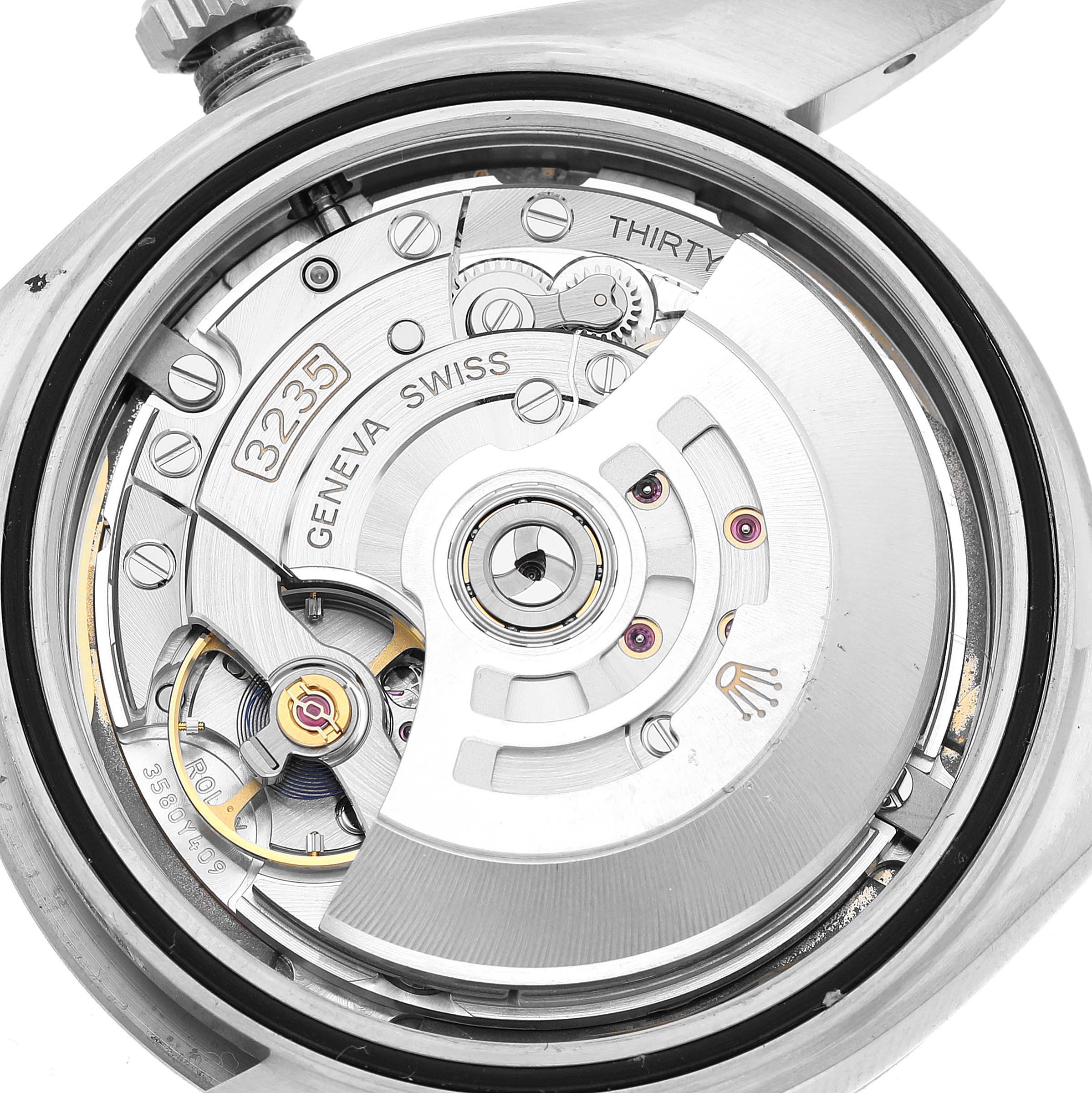 The image shows the inner mechanical movement of a Rolex Datejust 41 126334 Men's Stainless Steel White Dial, highlighting the rotor and intricate components.