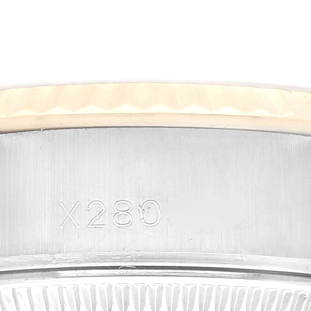 This close-up shows the brushed steel casing and part of the fluted bezel of a Rolex Datejust 69173 Women's Steel and Gold (two tone) Champagne Dial 69173 Women's Steel and Gold (two tone) Champagne Dial watch.