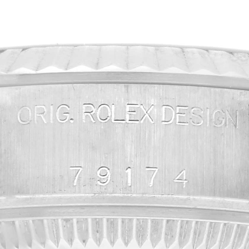 The image shows a close-up of the engraved case side of the Rolex Datejust 79174 Women's Stainless Steel Pink Dial 79174 Women's Stainless Steel Pink Dial, highlighting "ORIG. ROLEX DESIGN 79174".