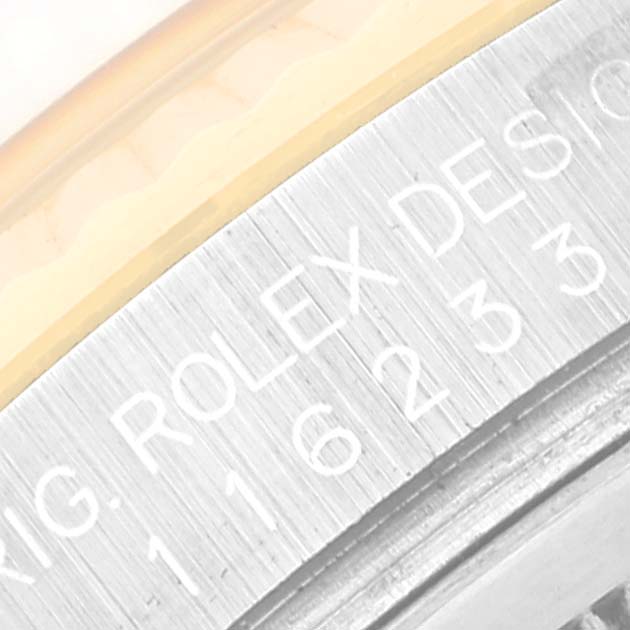 This close-up image shows the engraving on the edge of the case of a Rolex Datejust 116233 Men's Steel and Gold (two tone) Champagne Dial 116233 Men's Steel and Gold (two tone) Champagne Dial watch.