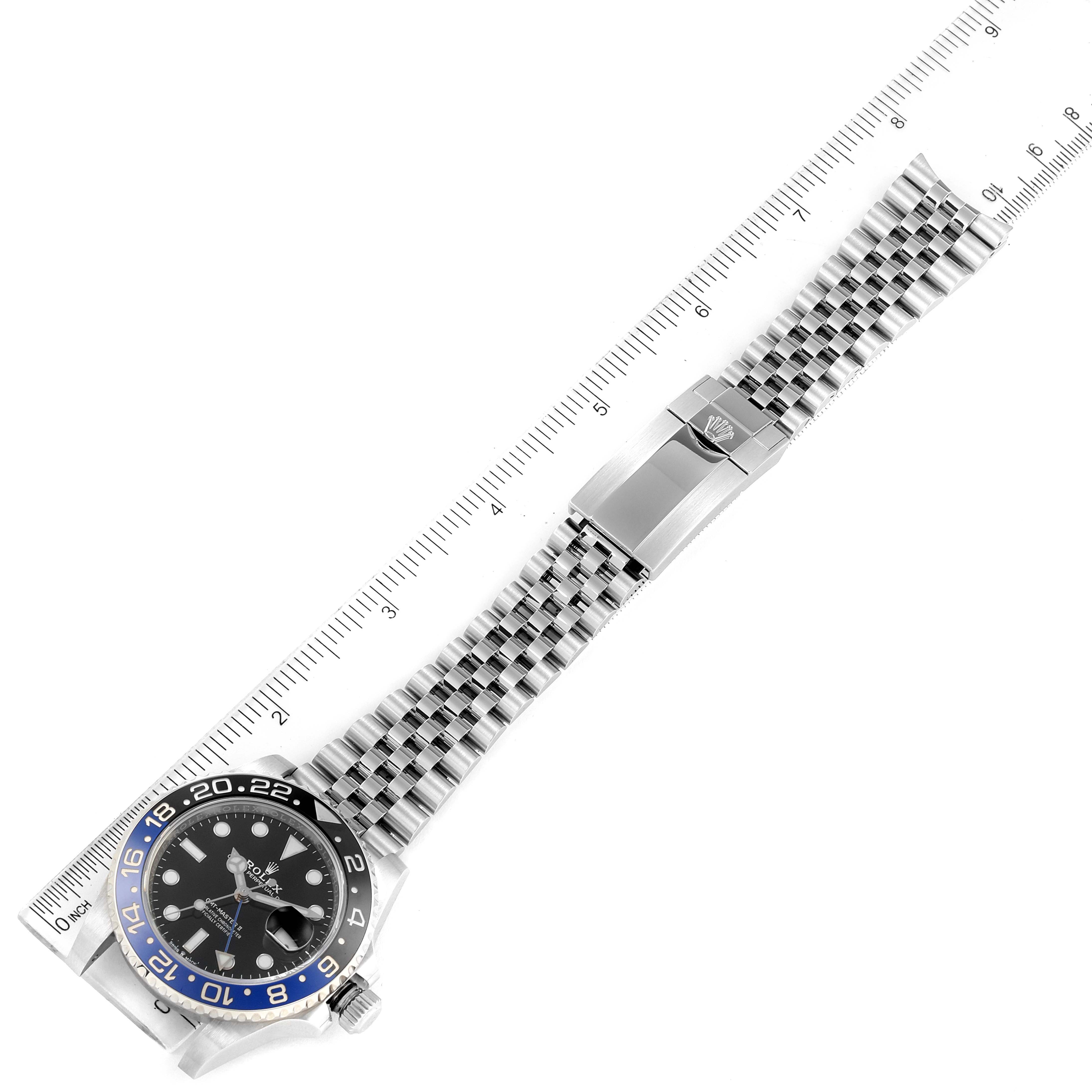 This image shows a Rolex GMT-Master 126710 Men
s Stainless Steel Black Dial 126710 Men
s Stainless Steel Black Dial watch laid flat, with the face, bezel, bracelet, and clasp visible, along with a ruler.