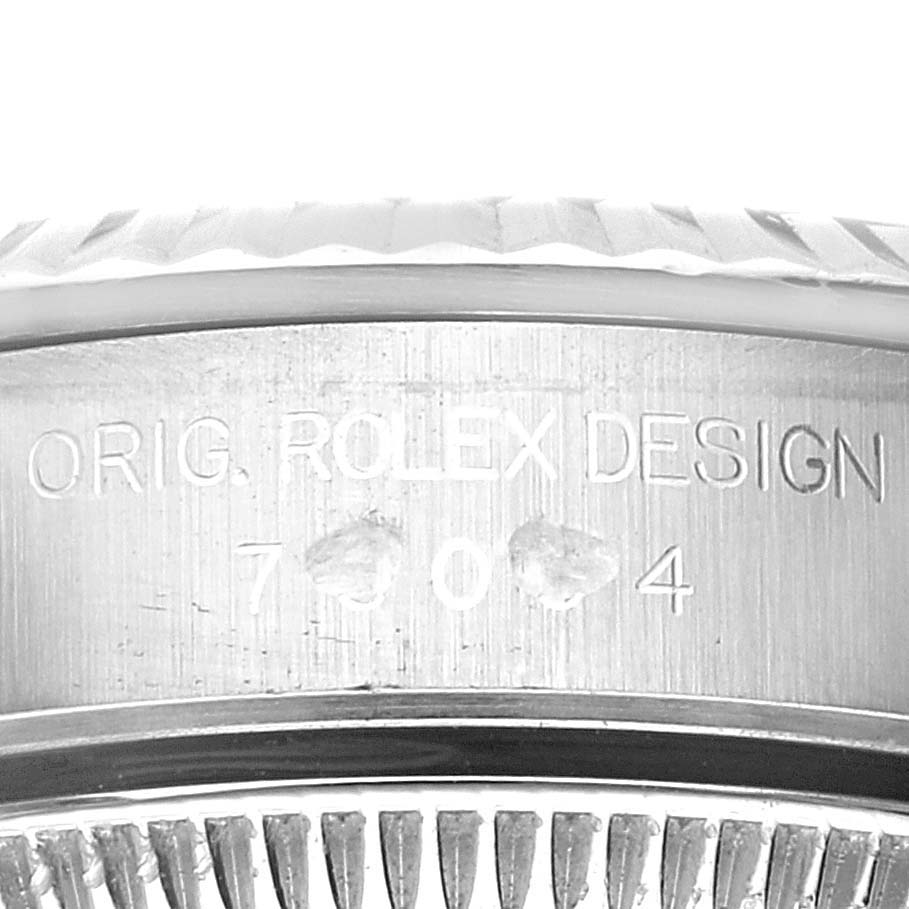 The image shows a close-up of the side of a Rolex Oyster Perpetual 76094 Women's Stainless Steel Blue Dial 76094 Women's Stainless Steel Blue Dial watch, highlighting its engraved design details.