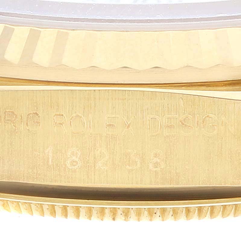 The image shows a close-up of the case side of the Rolex President 18238 Men's Yellow Gold White Dial 18238 Men's Yellow Gold White Dial model, revealing engraved text and part of the fluted bezel.