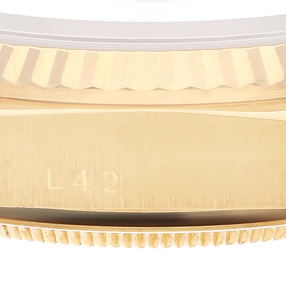 The image shows the side view of a Rolex President 18238 Men's Yellow Gold White Dial 18238 Men's Yellow Gold White Dial model, highlighting its fluted bezel and engraved serial number.