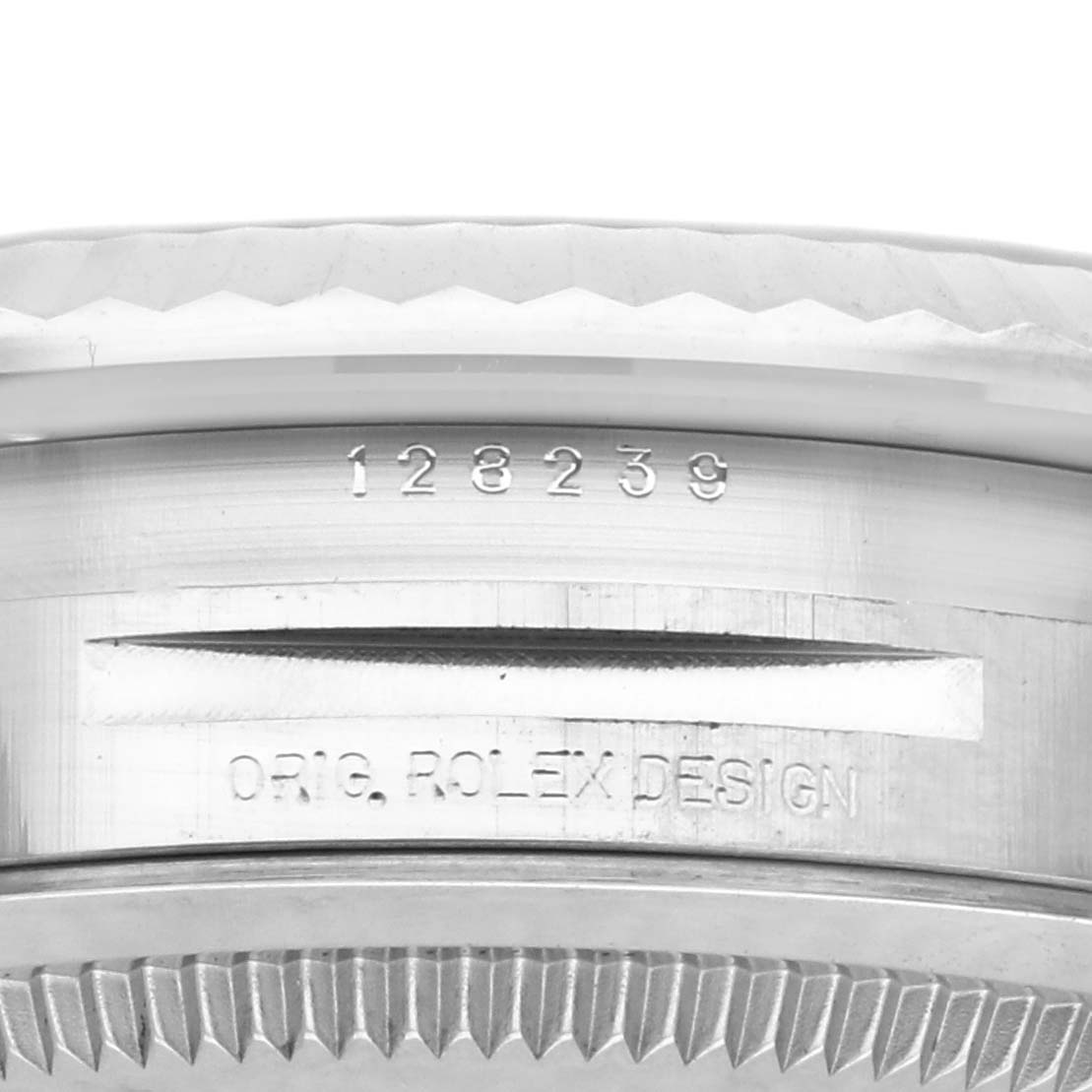 The image shows a close-up of the Rolex President 128239 Men
s White Gold Blue Dial 128239 Men
s White Gold Blue Dial model
s bezel with engraved serial number and "ORIG. ROLEX DESIGN."